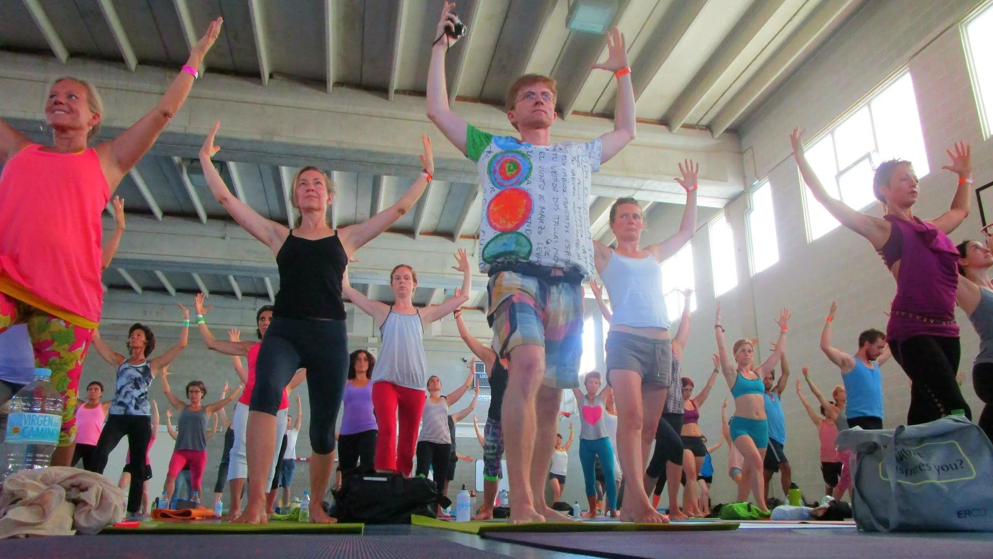 Groupe de personnes pratiquant le yoga dans une salle intérieure lumineuse