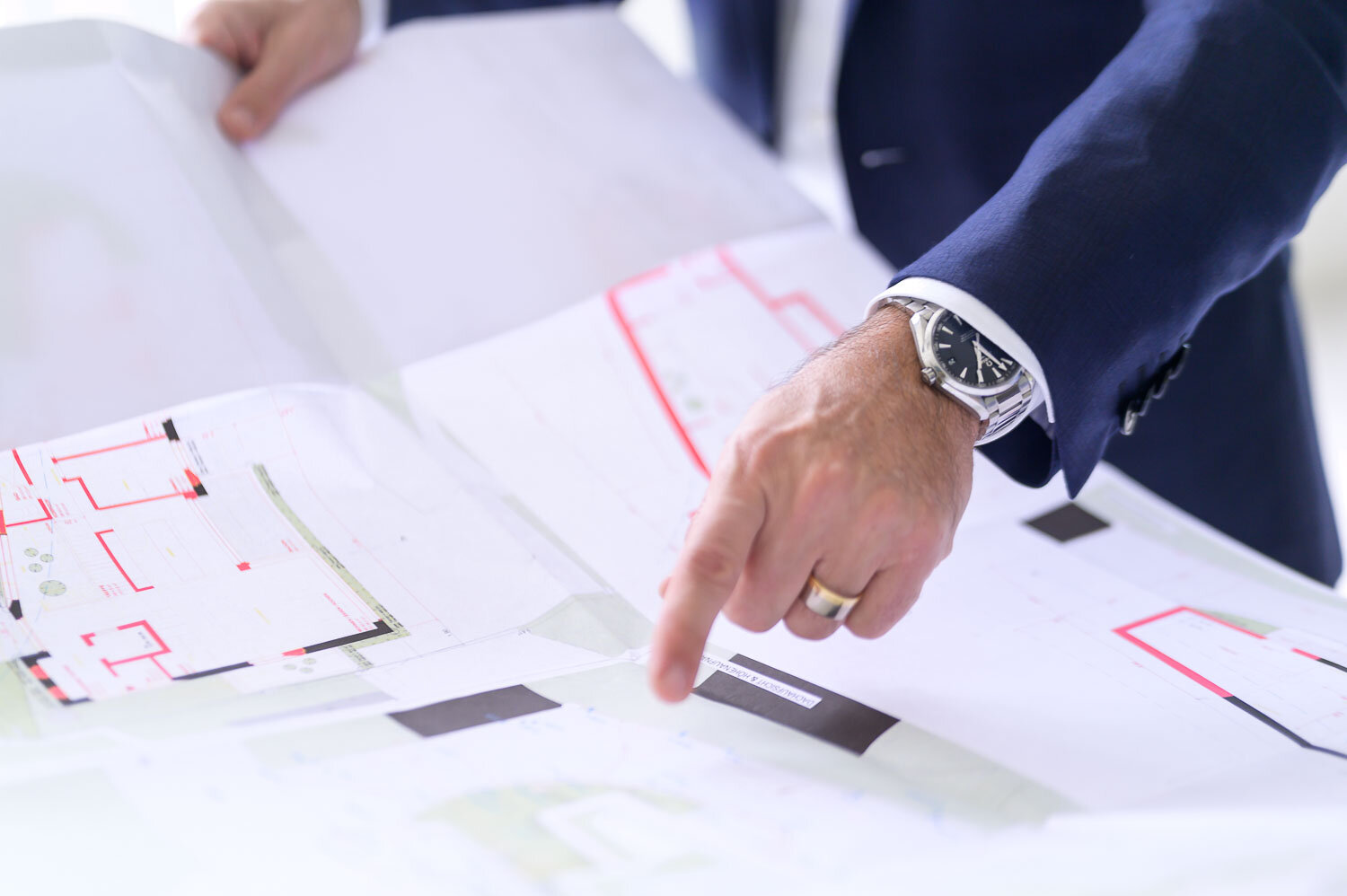 A hand explains details on a construction plan at Thaler Berz Partner Solicitors
