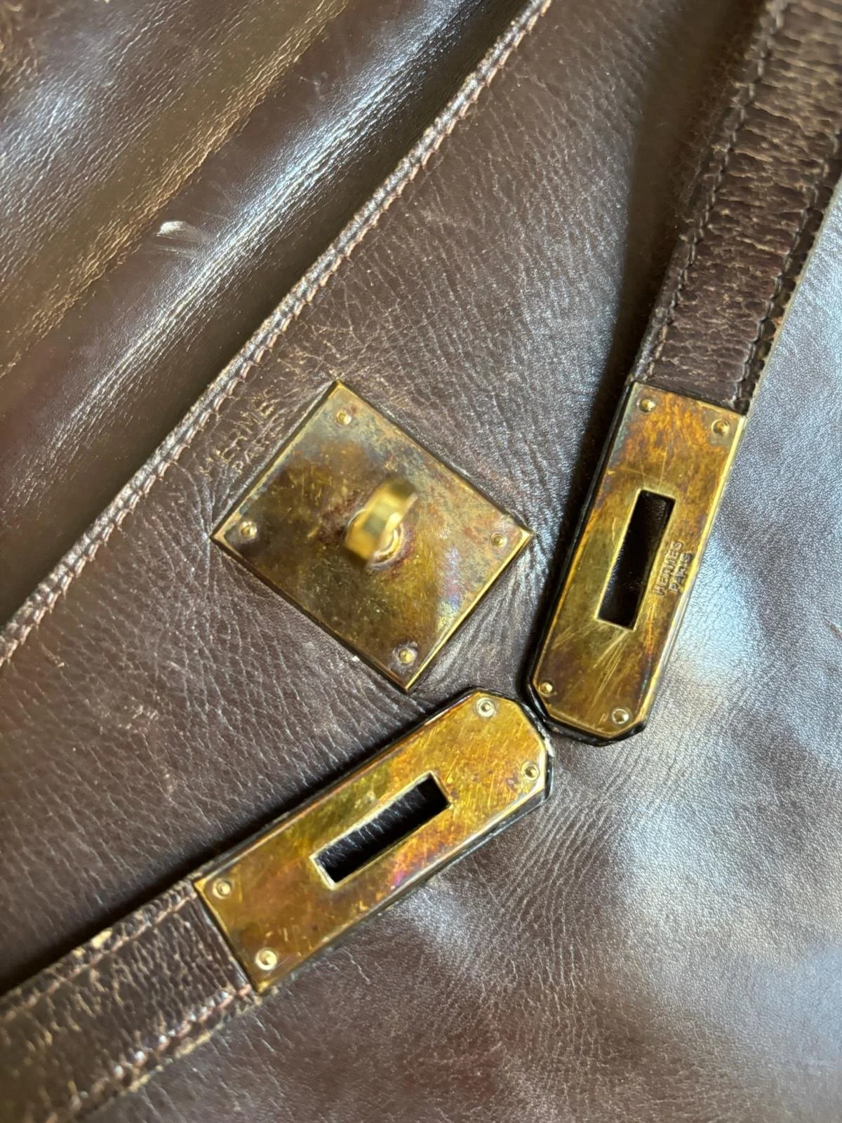 Sac Hermès Kelly vintage, poignée cassée et cuir usé. Bijouterie et partie métalliques noircies
