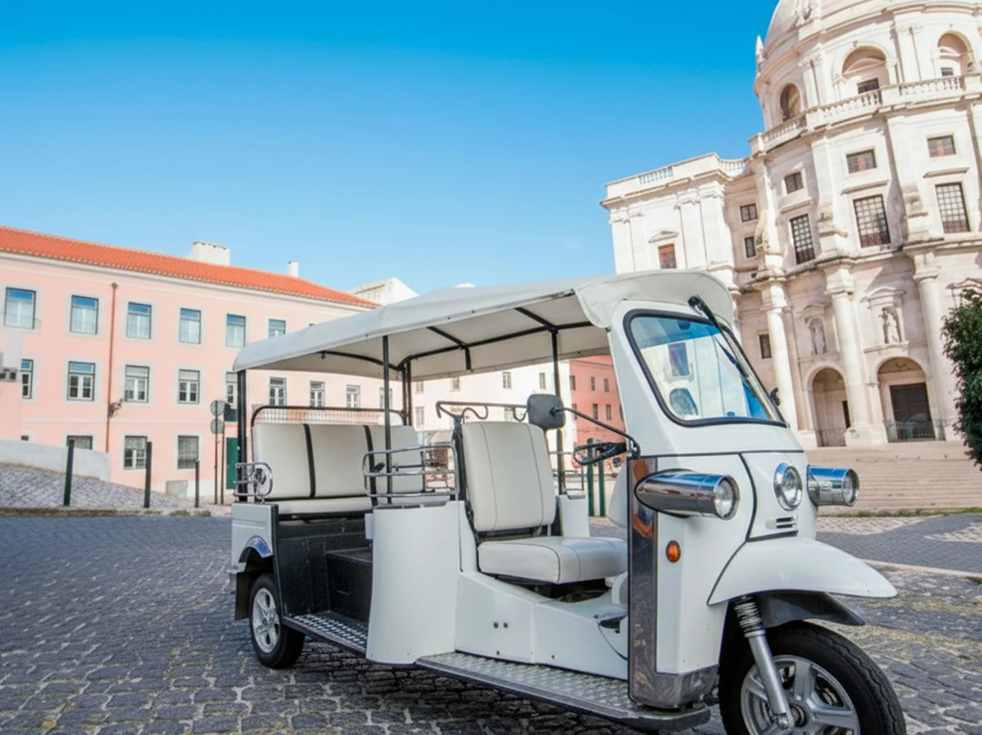 Táxi de triciclo branco com teto e assentos internos, em uma praça com edifícios históricos ao fundo.
