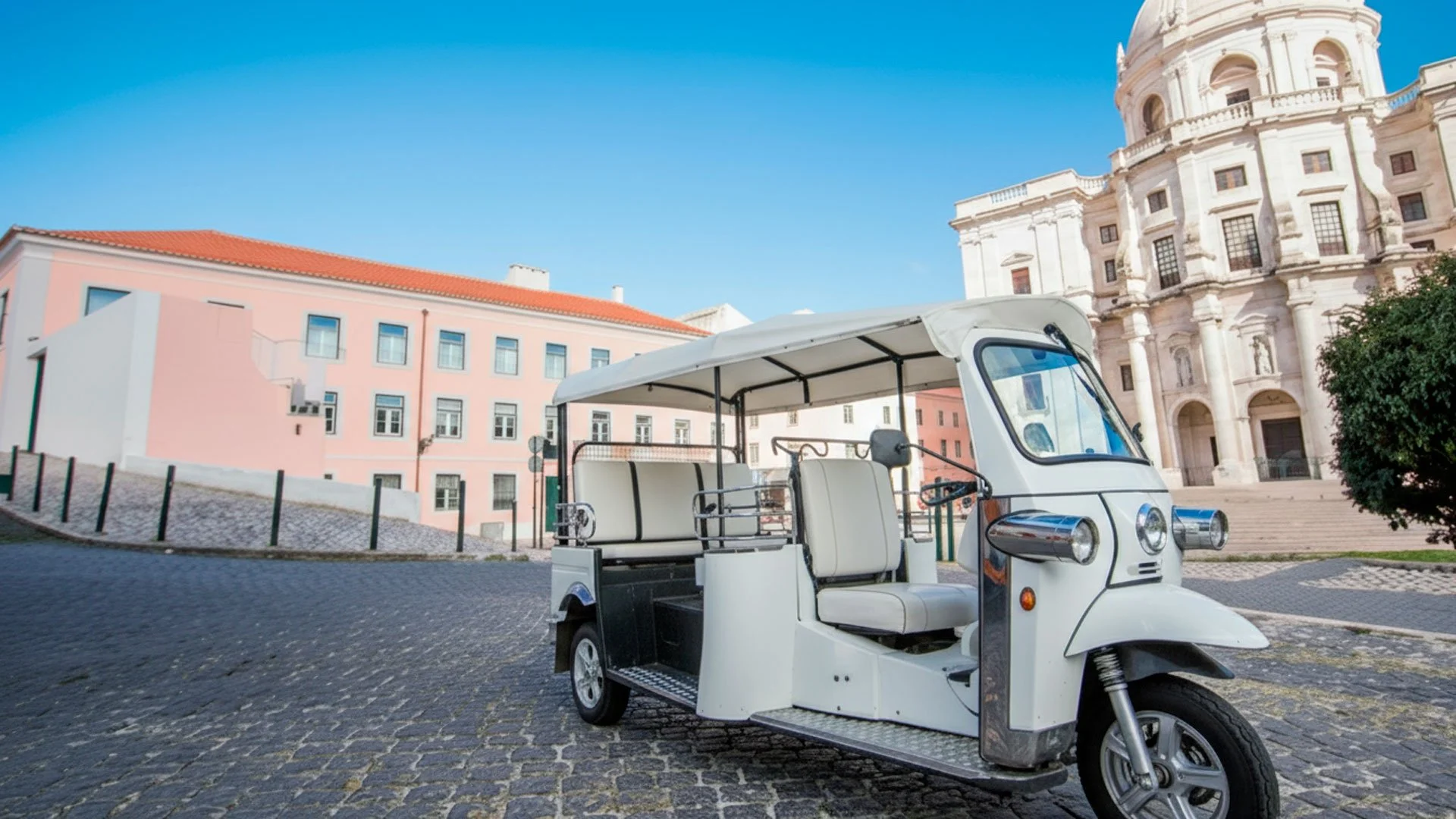 Carrinho eléctrico branco estacionado em uma praça com edifícios históricos ao fundo.