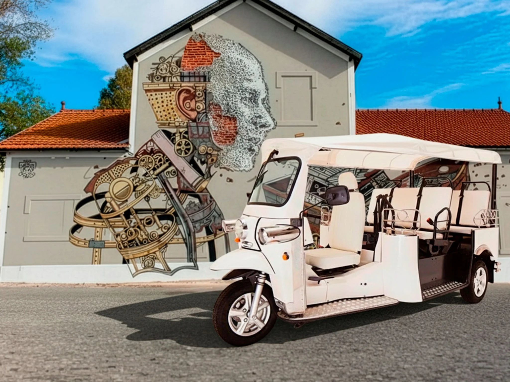 Uma rampa de rua com um mural artístico de um perfil de rosto humano feito com elementos mecânicos e tecnológicos. Na frente, um veículo elétrico de três rodas branco.