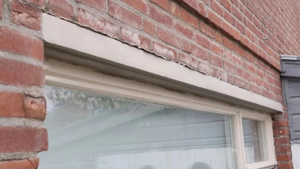 Herstel van betonnen latei boven raam in bakstenen gevel