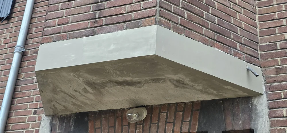 Betonreparatie van betonnen luifel bij bakstenen gevel door BudRaf Betonreparatie