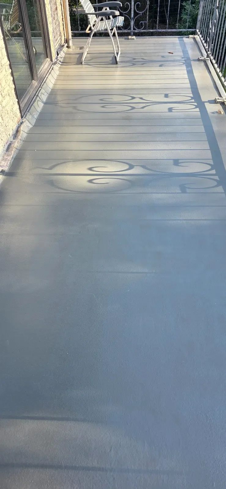 Afgewerkte balkonvloer met grijze beschermende coating tegen vocht en slijtage.
