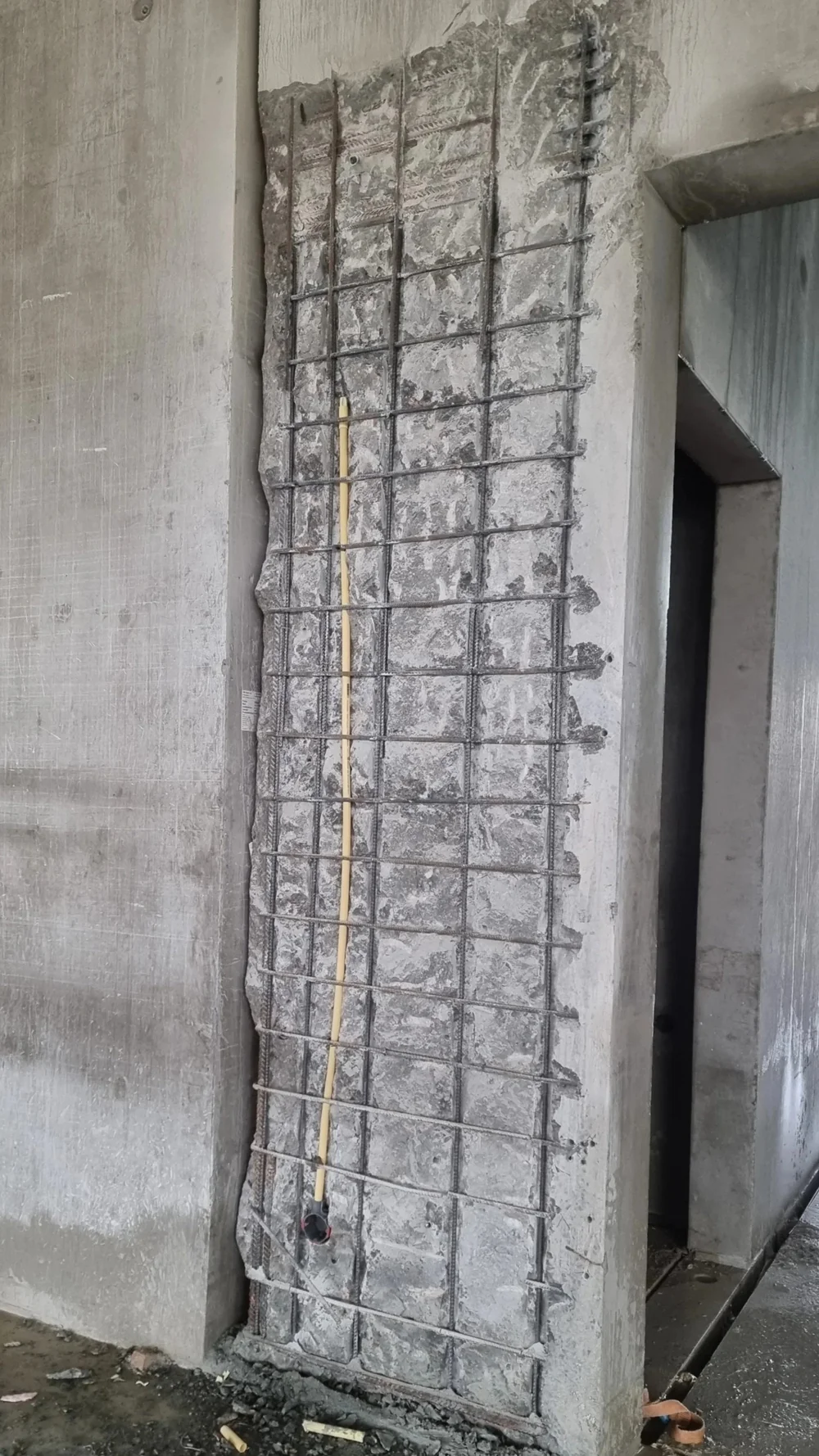 Constructieve betonreparatie met zichtbare wapening aan een prefab betonnen kolom