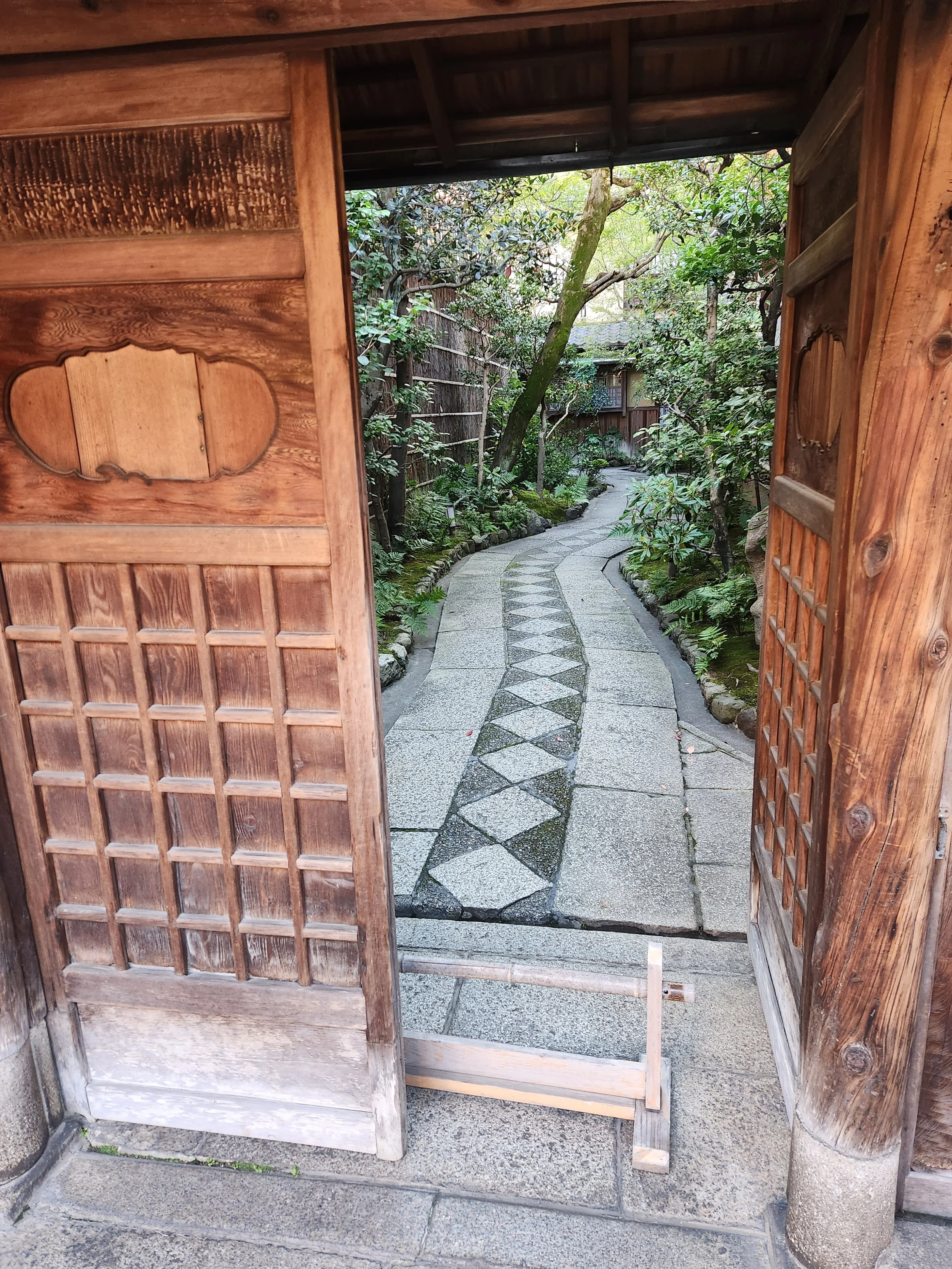 An open door to a residence offers a glimpse of the walkway and garden