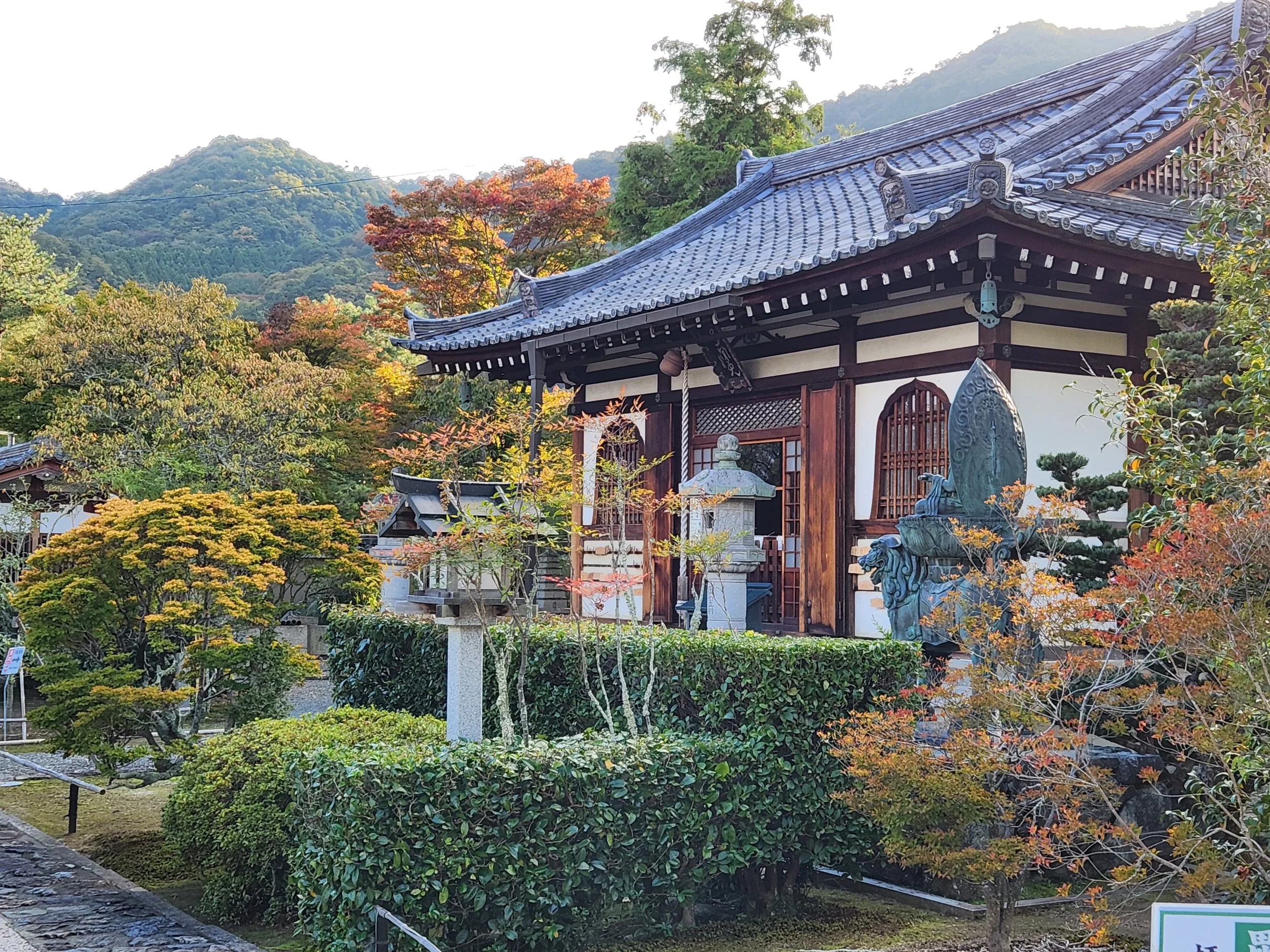 Traditional Japanese building surrounded by colorful autumn trees and landscaped garden.