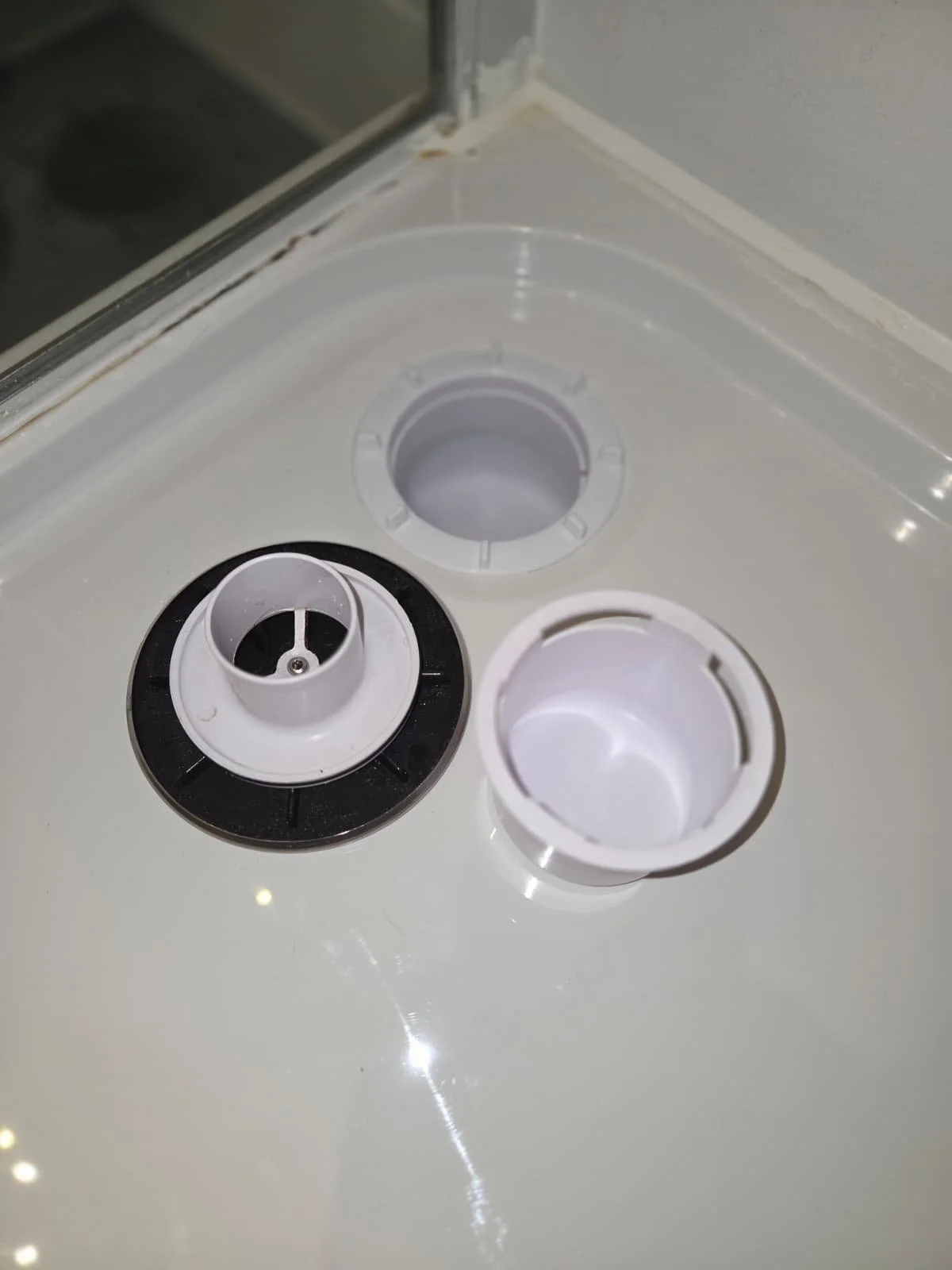 Disassembled plastic components on a white surface.