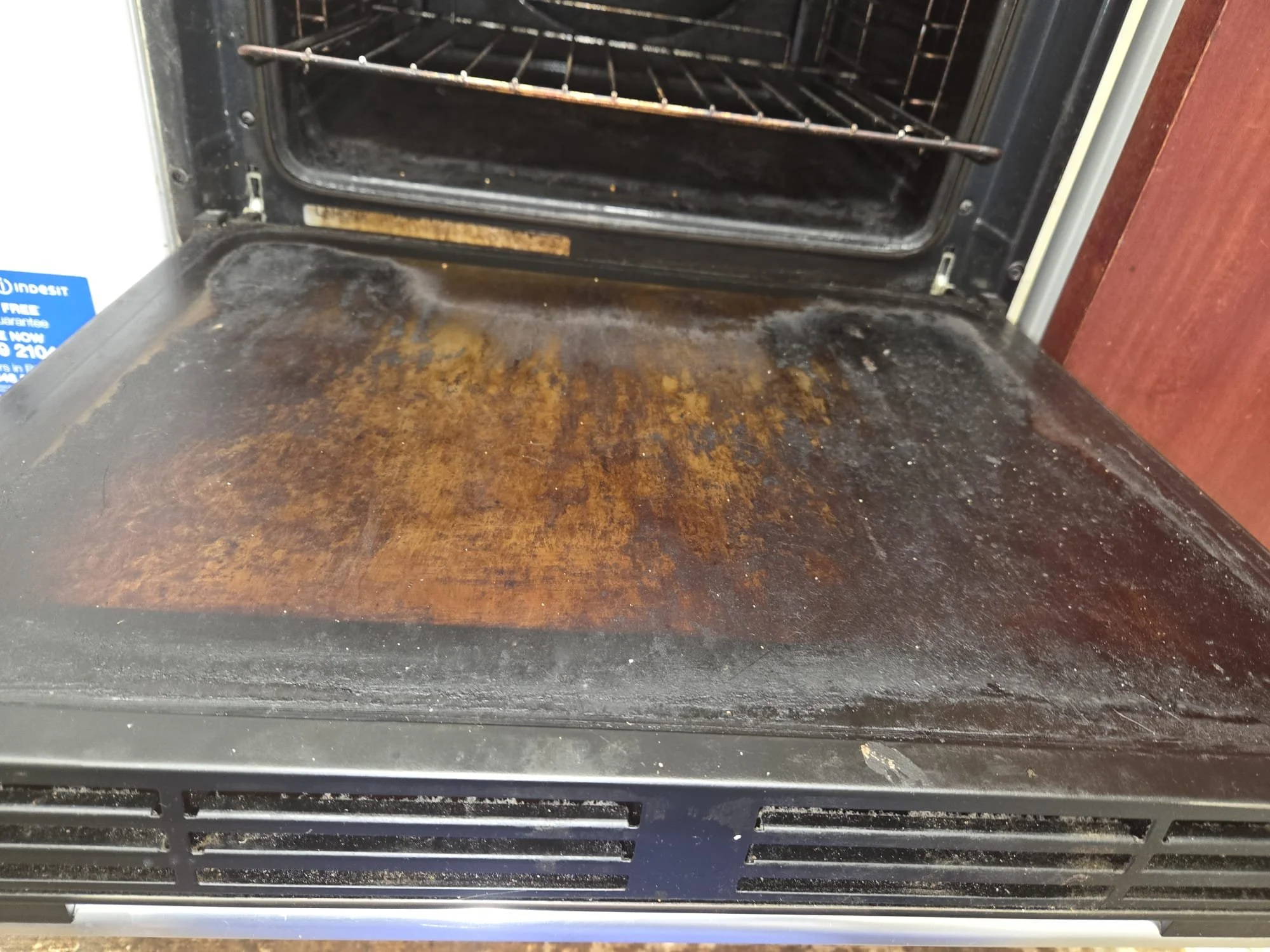 Dirty and greasy stovetop surface with stains, dirt, and food residue.