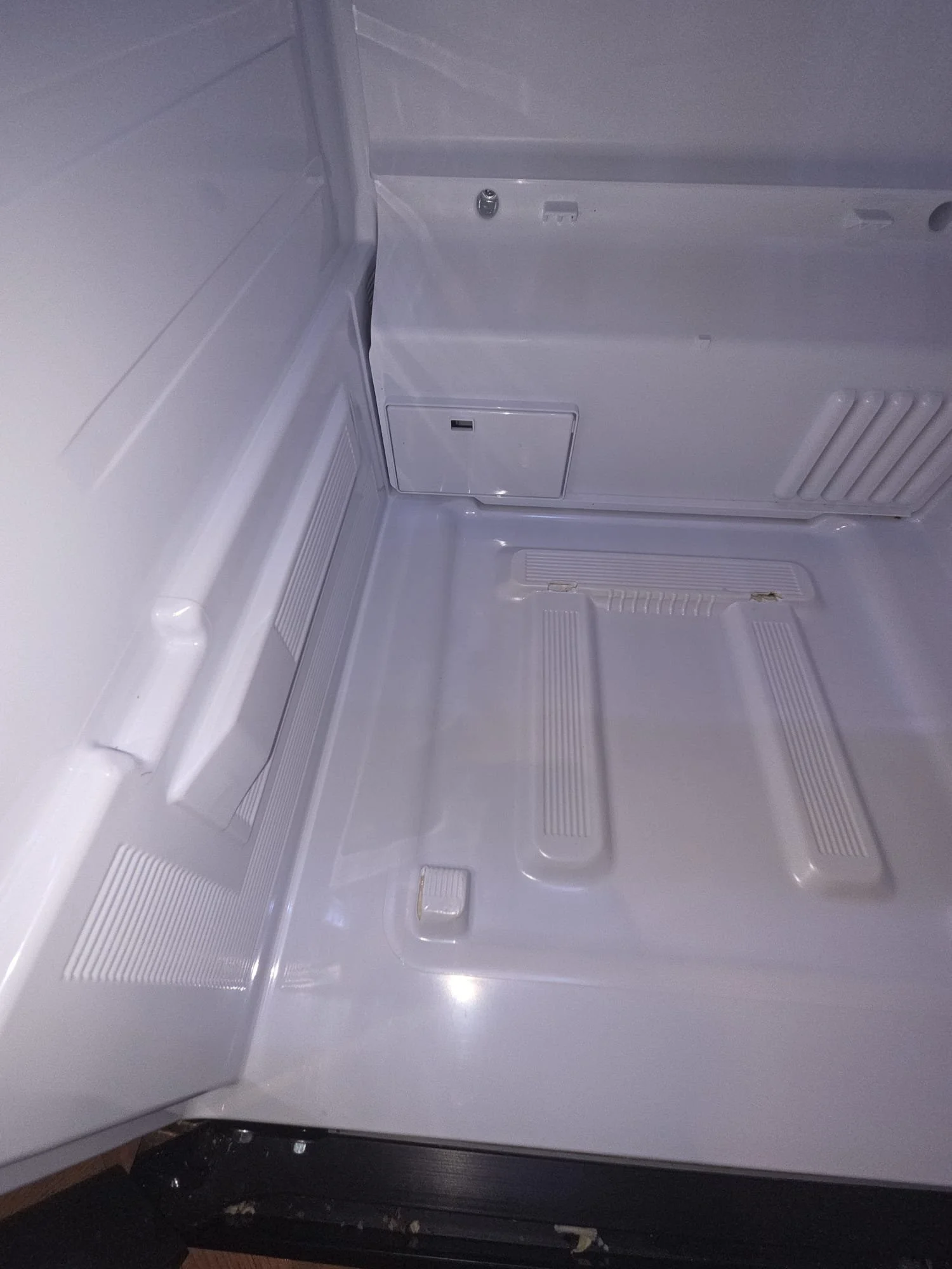 Inside of an empty refrigerator with a white interior.