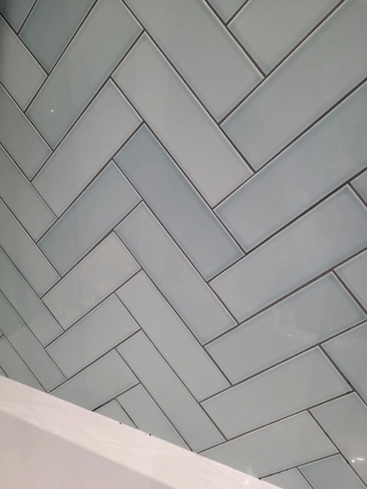 Close-up of gray ceramic tile floor arranged in a herringbone pattern