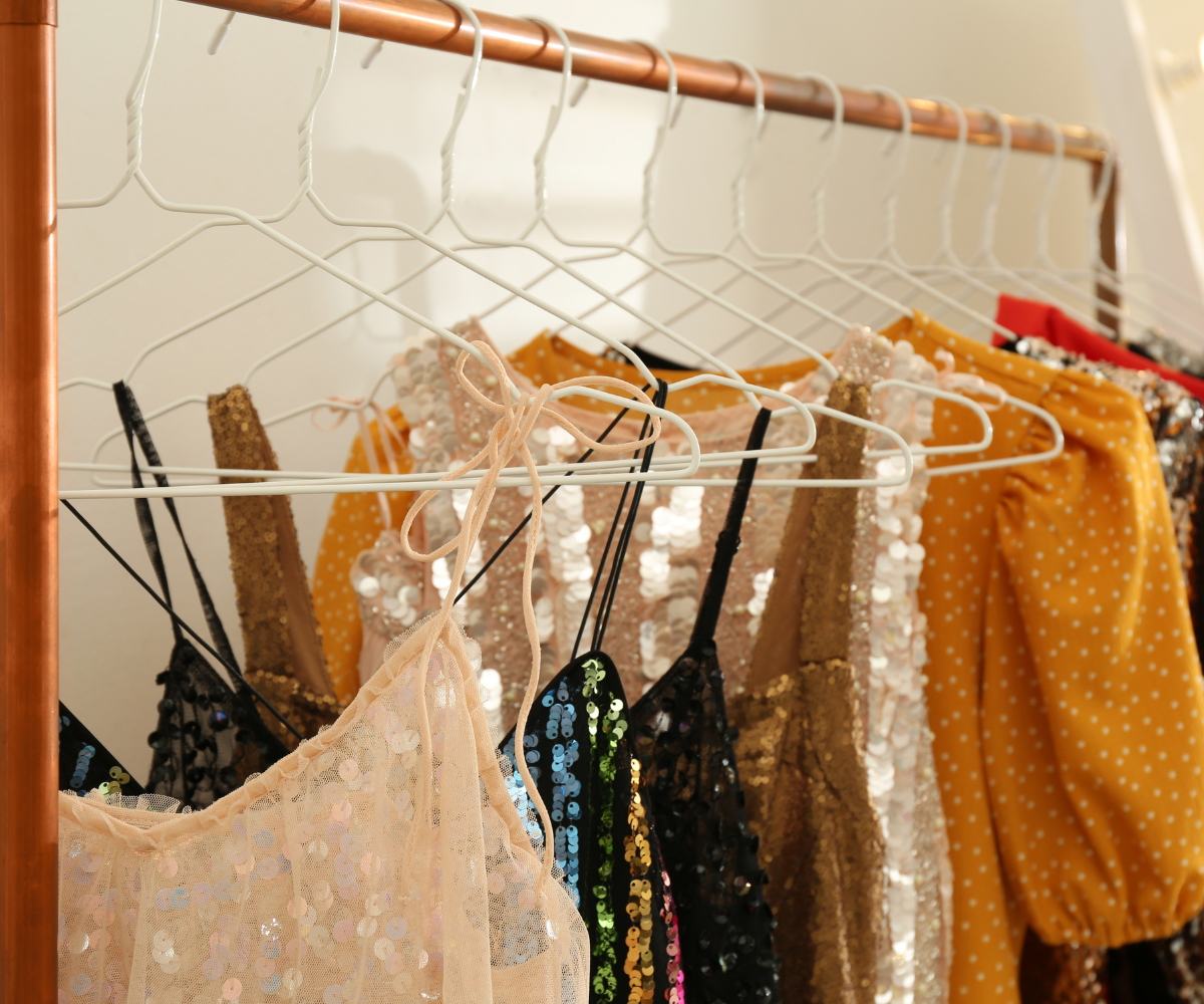 Rõivad, mis ripuvad riidepuudel – nende seas litritega topid ja täpilised pluusid.