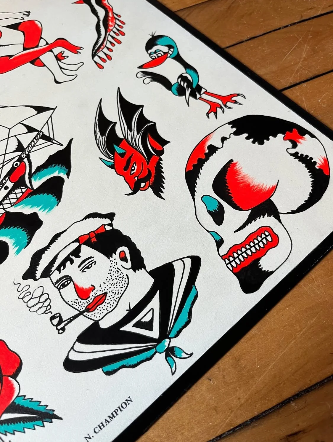 A collection of traditional tattoo-style illustrations featuring a skull, a sailor with a pipe, a woman with a headscarf, a devil, a bird, and a tattoo machine, primarily in black, red, blue, and white colors.