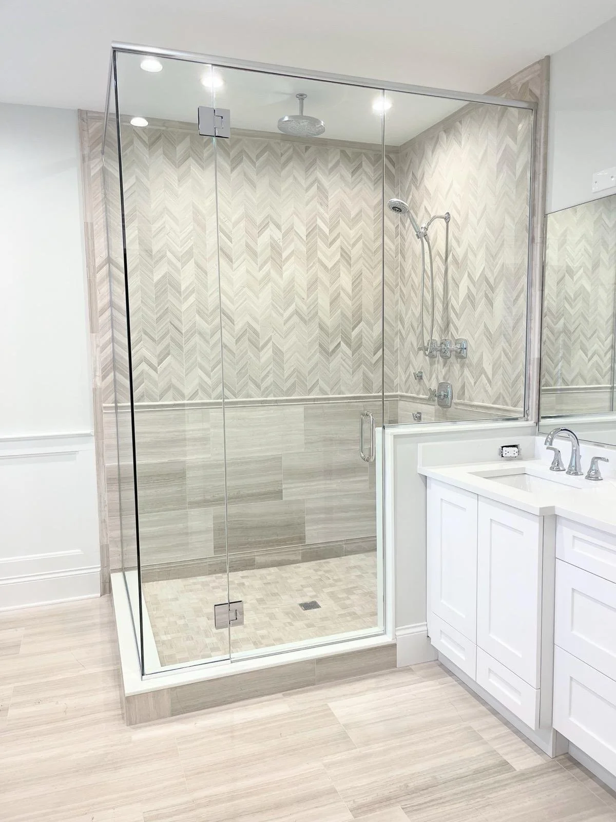 Bathroom with a glass shower enclosure and a white vanity with a sink.