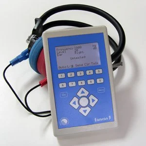 Calibrated audiometer used for OSHA-compliant hearing tests by Precision Mobile Testing, showing blue display screen and connected headphones.