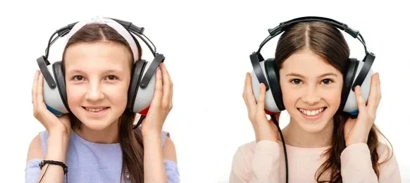 Two smiling students wearing headphones during a school hearing screening administered by a company such as Precision Mobile Testing.