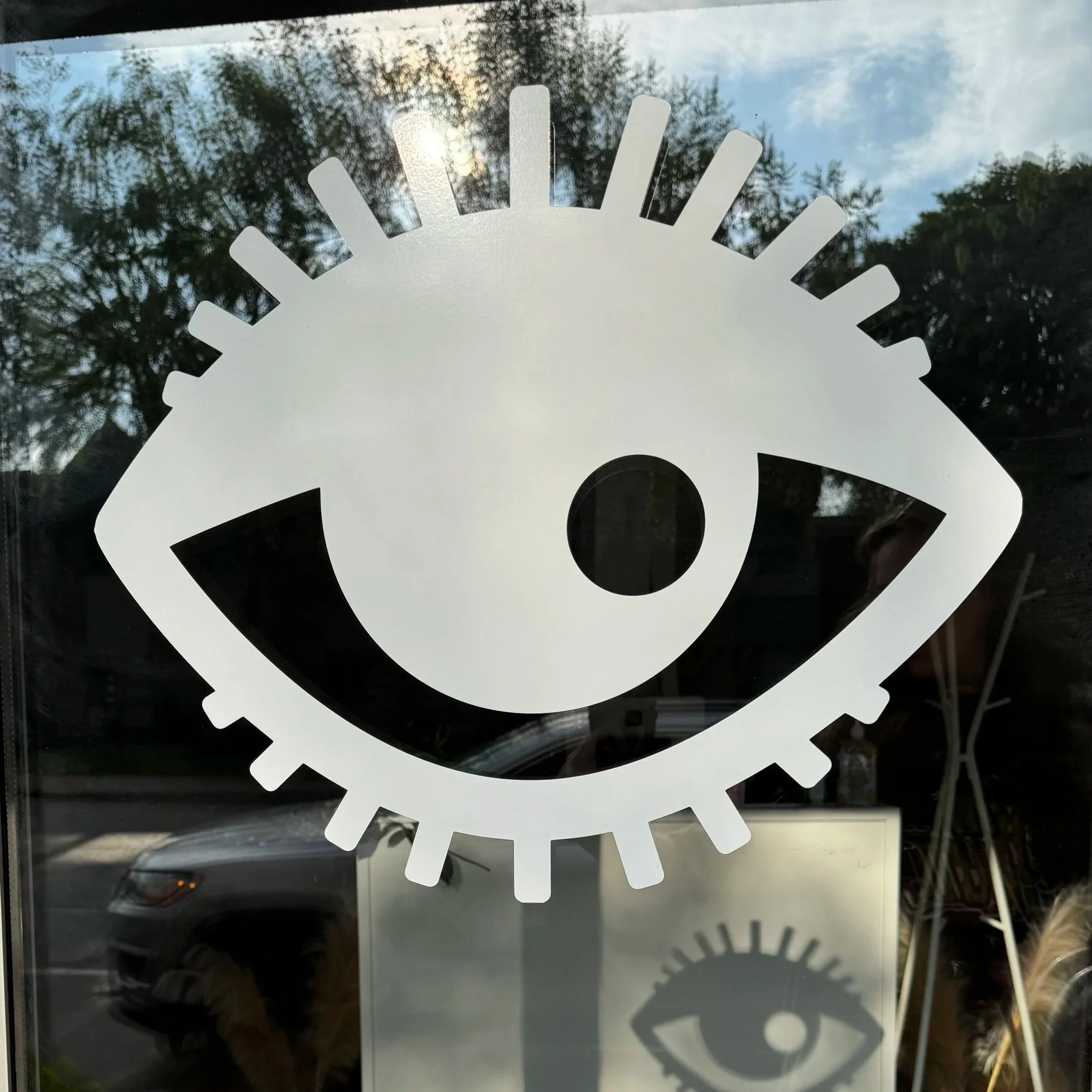 Decorative frosted window sticker featuring clock gears with a partial view of the outdoors, including trees and a cloudy sky in Mac grove land, Saint Paul