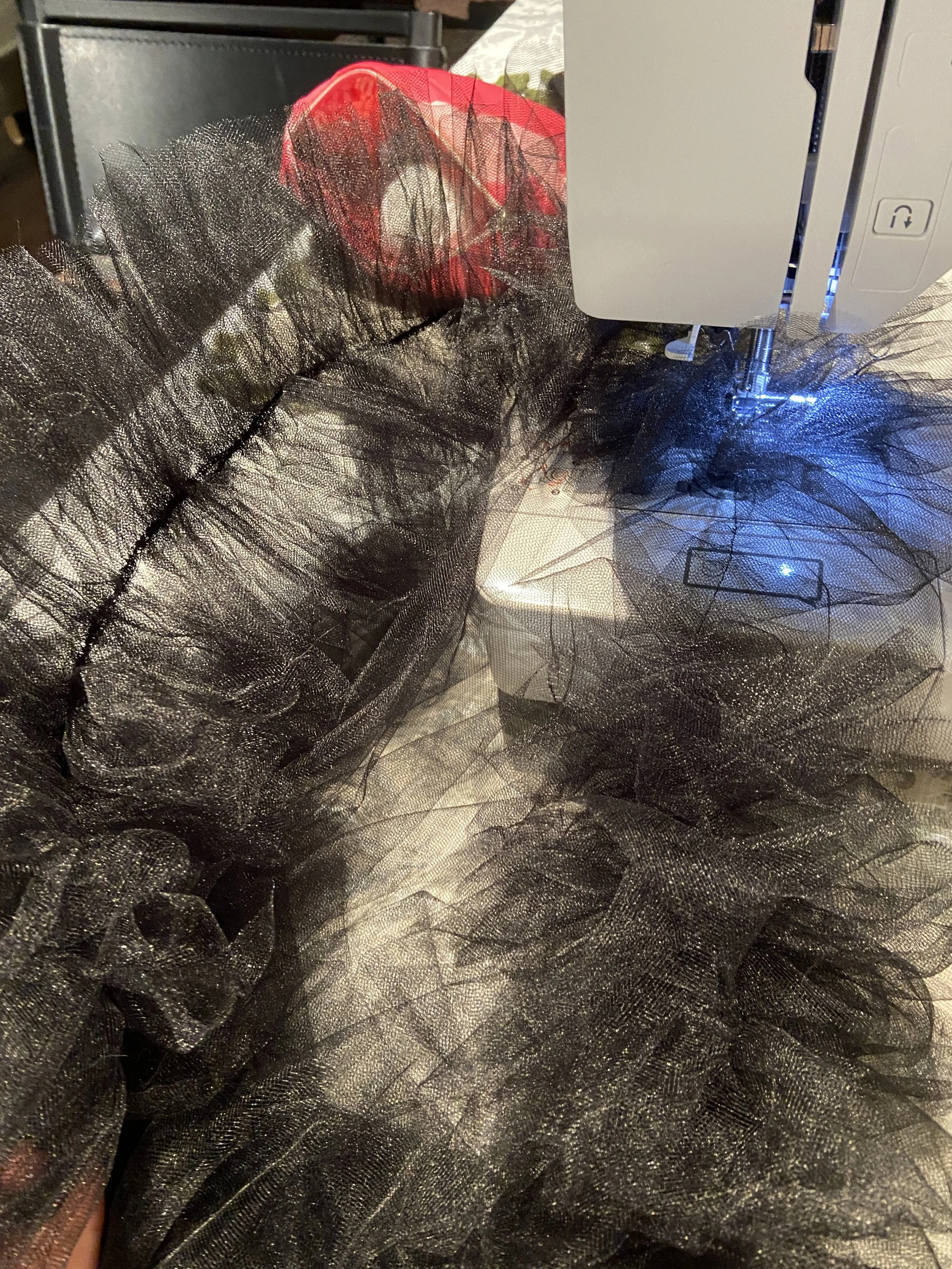 Attaching all the gathers to the hem of the outermost layer of tulle.