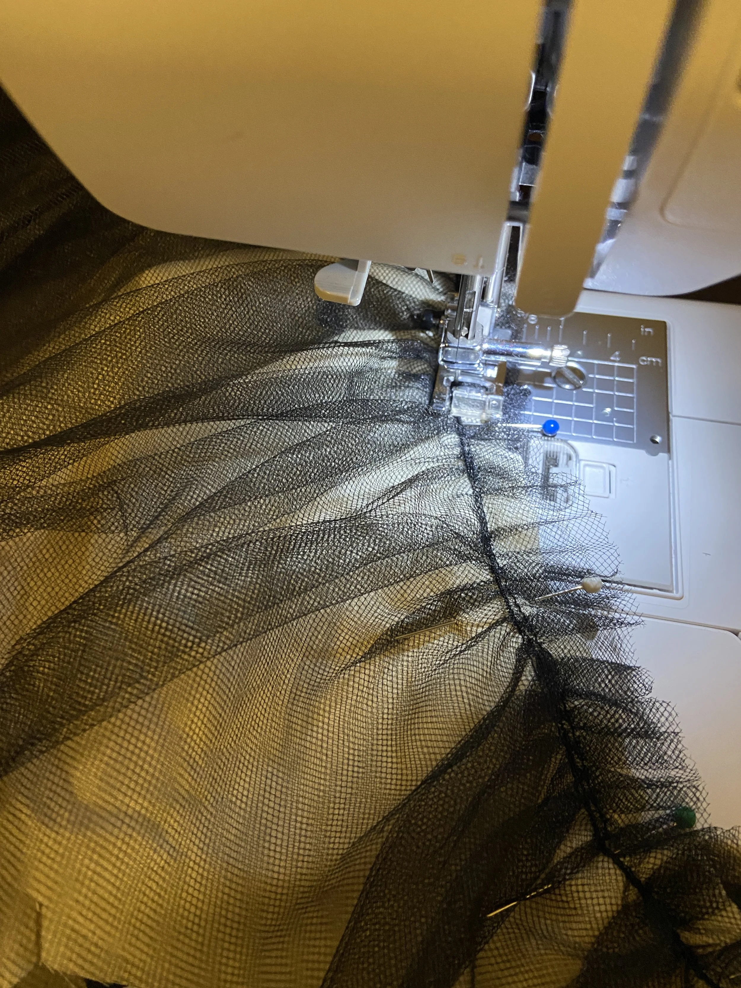 Basting the two layers of tulle to the "fashion fabric" muslin layer to attach.