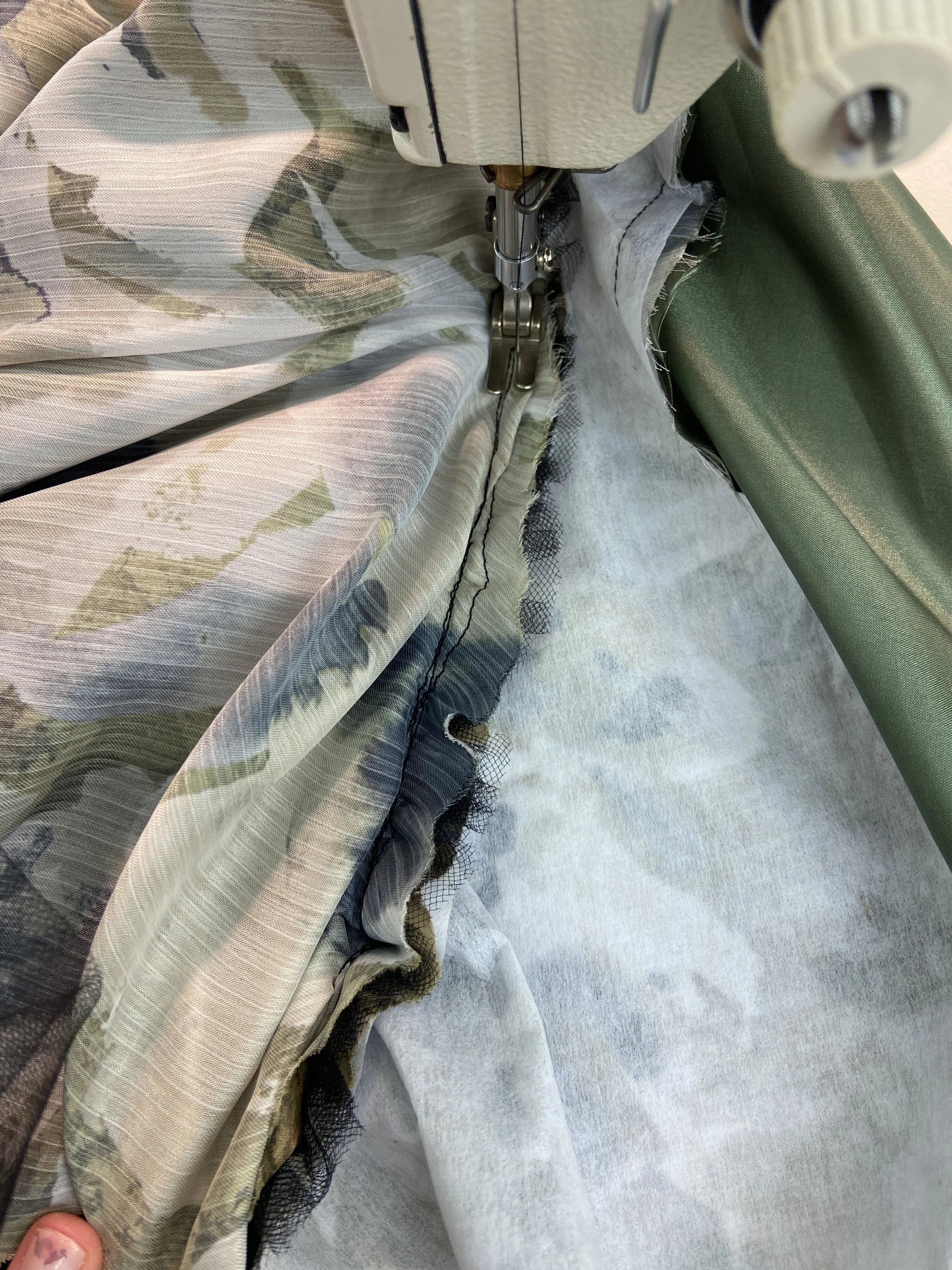 Understitching all three layers' seam allowances to the inner lining of the dress at the neckline.