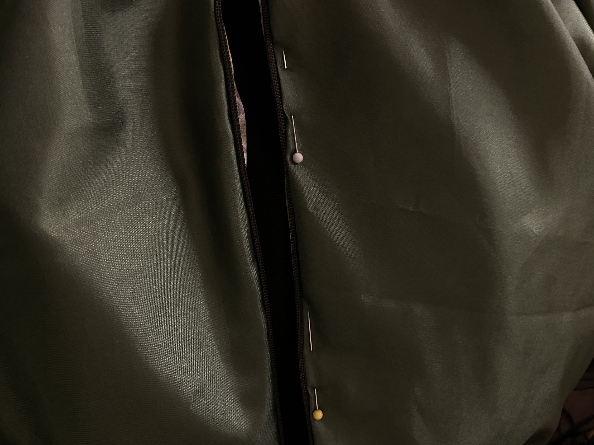 Whip stitching the lining layer to the invisible zipper panels.