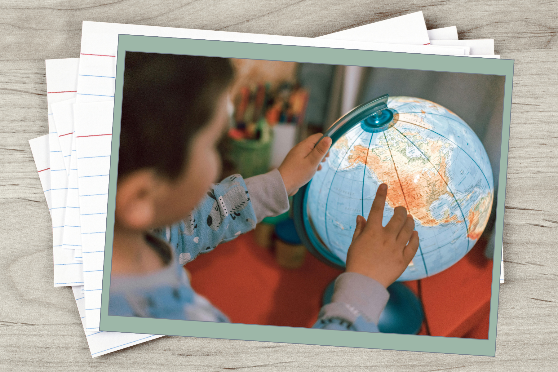 Child pointing at a globe, touching the map of Asia with one finger and holding the globe with the other hand.