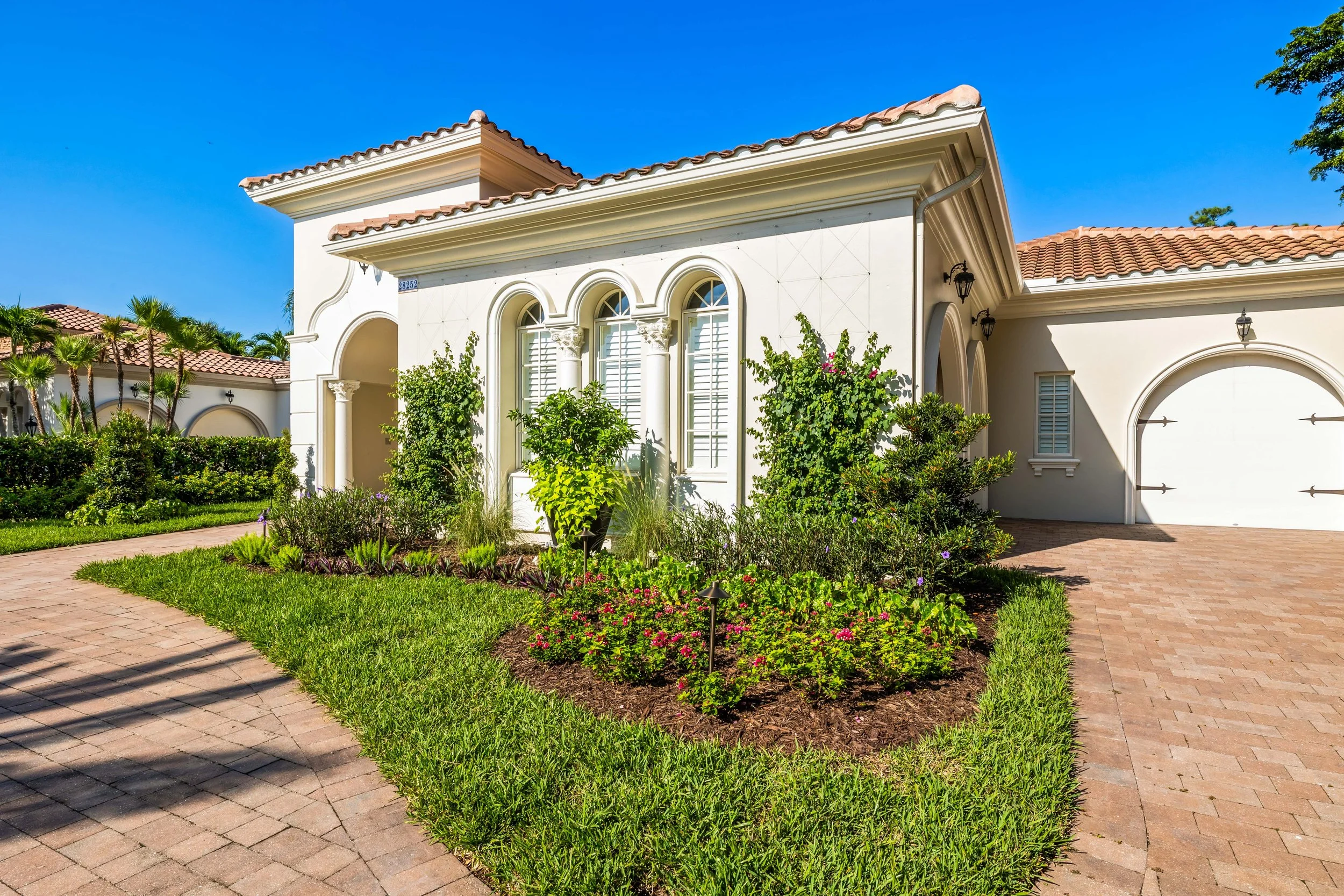 Landscape bed along side elevation featuring flowering shrubs, accent trees, and soft curbing.