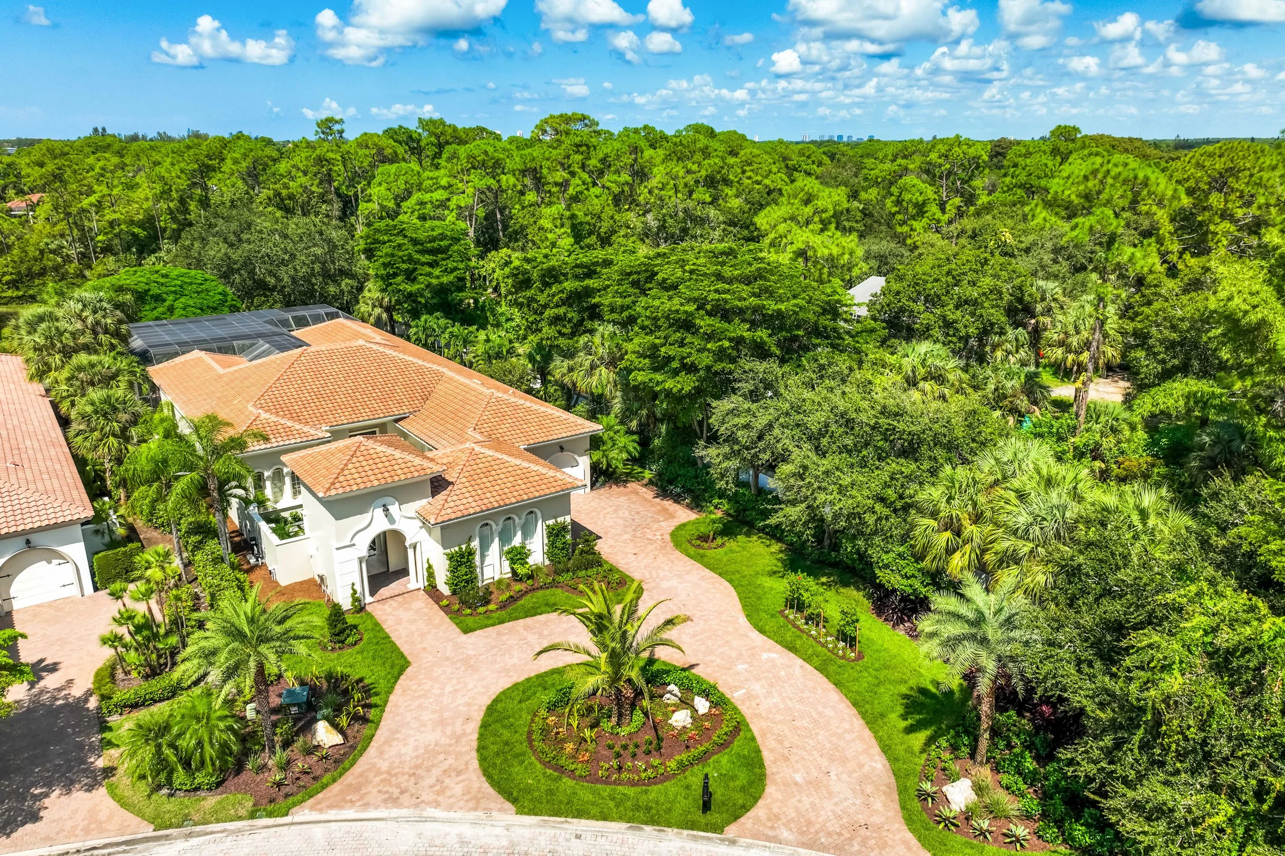 Aerial view of circular paver driveway and manicured front yard landscape design in Naples, FL.