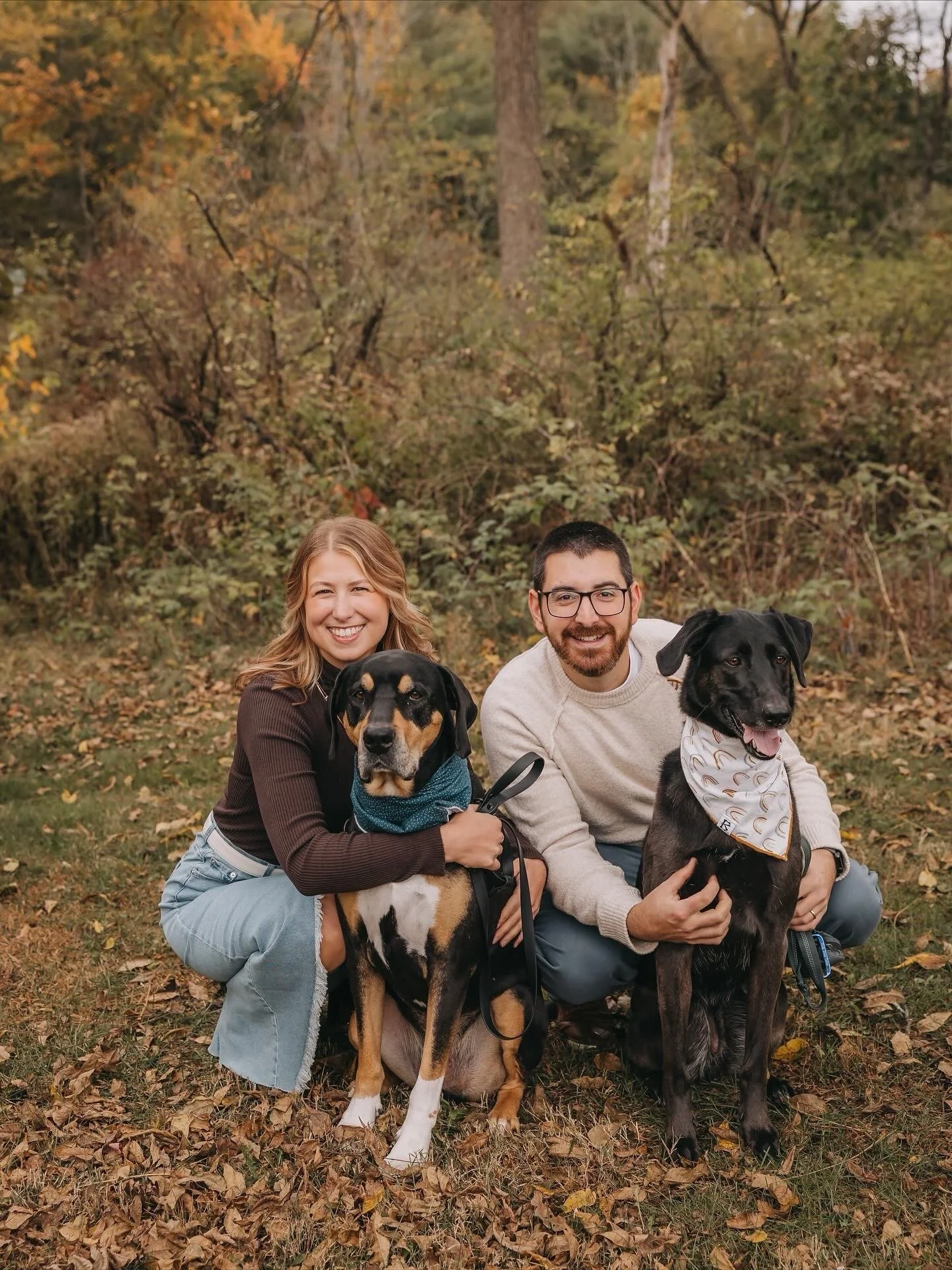 Family picture of owner, Karissa, with her husband and two large dogs in a leafy fall field.