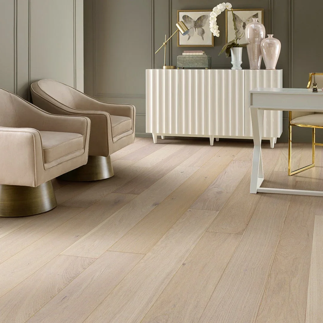 Living room with beige armchairs, white sideboard, and decorative vases and artwork