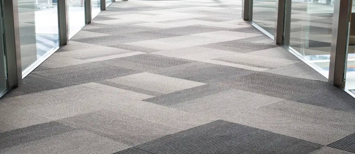 Empty corridor with glass walls and a patterned carpet floor.