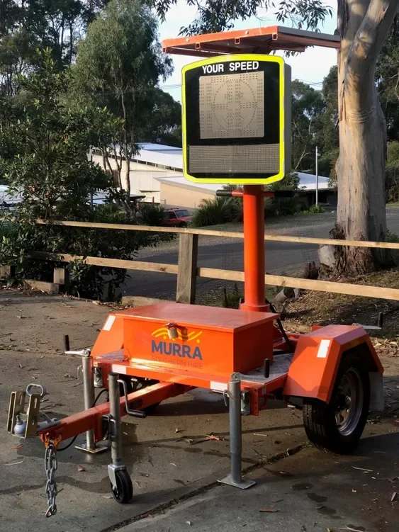 Portable radar speed display sign on trailer with an electronic message board on top, used to monitor and display vehicle speeds.