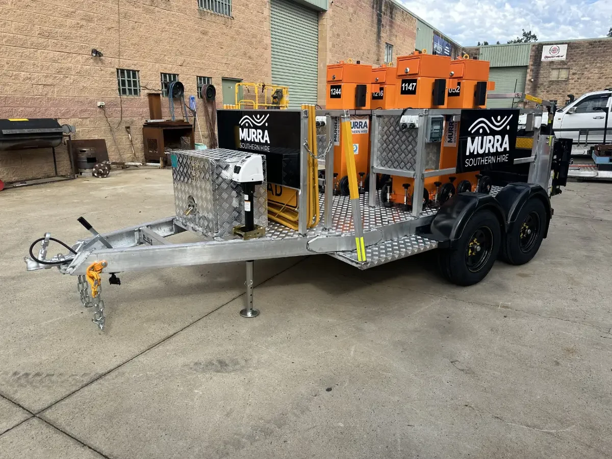 Mobile work trailer with orange electrical boxes and equipment, branded with Murra Southern Hire decals, parked outdoors on concrete.