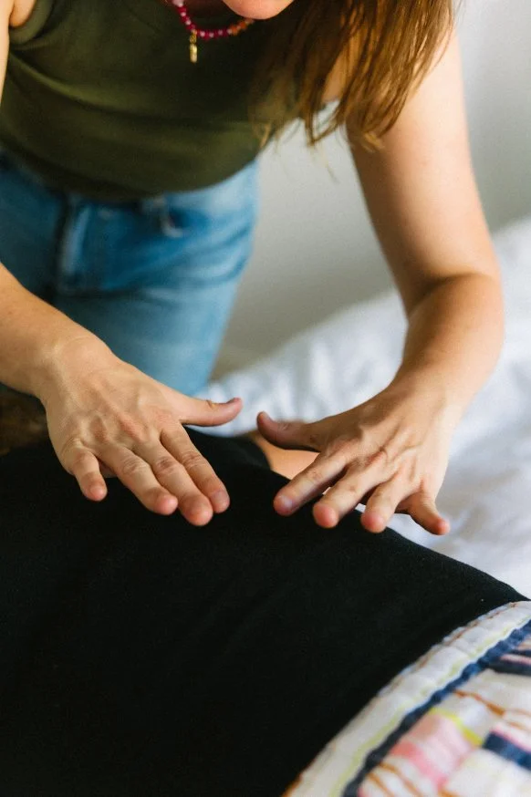 Practitioner performing gentle hands-on spinal energy work during a Spinal Flow or Spinal Energetics session.