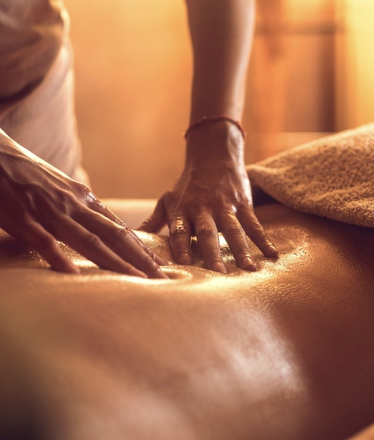 Hands massaging an oiled back