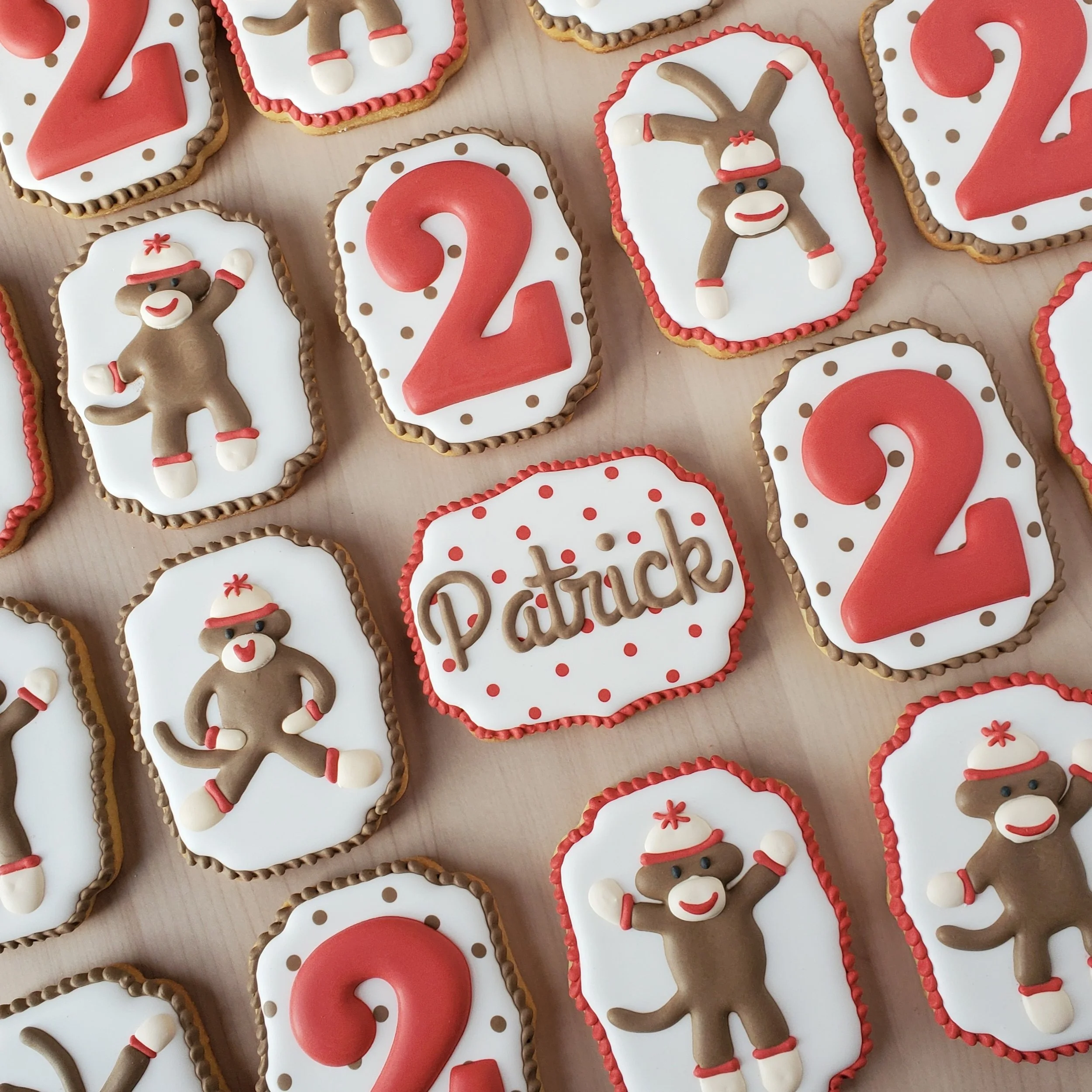 Decorated cookies with red, white, and brown colors celebrating Patrick's Day, featuring the name "Patrick" and numbering for 2022, including gingerbread men wearing Santa hats.