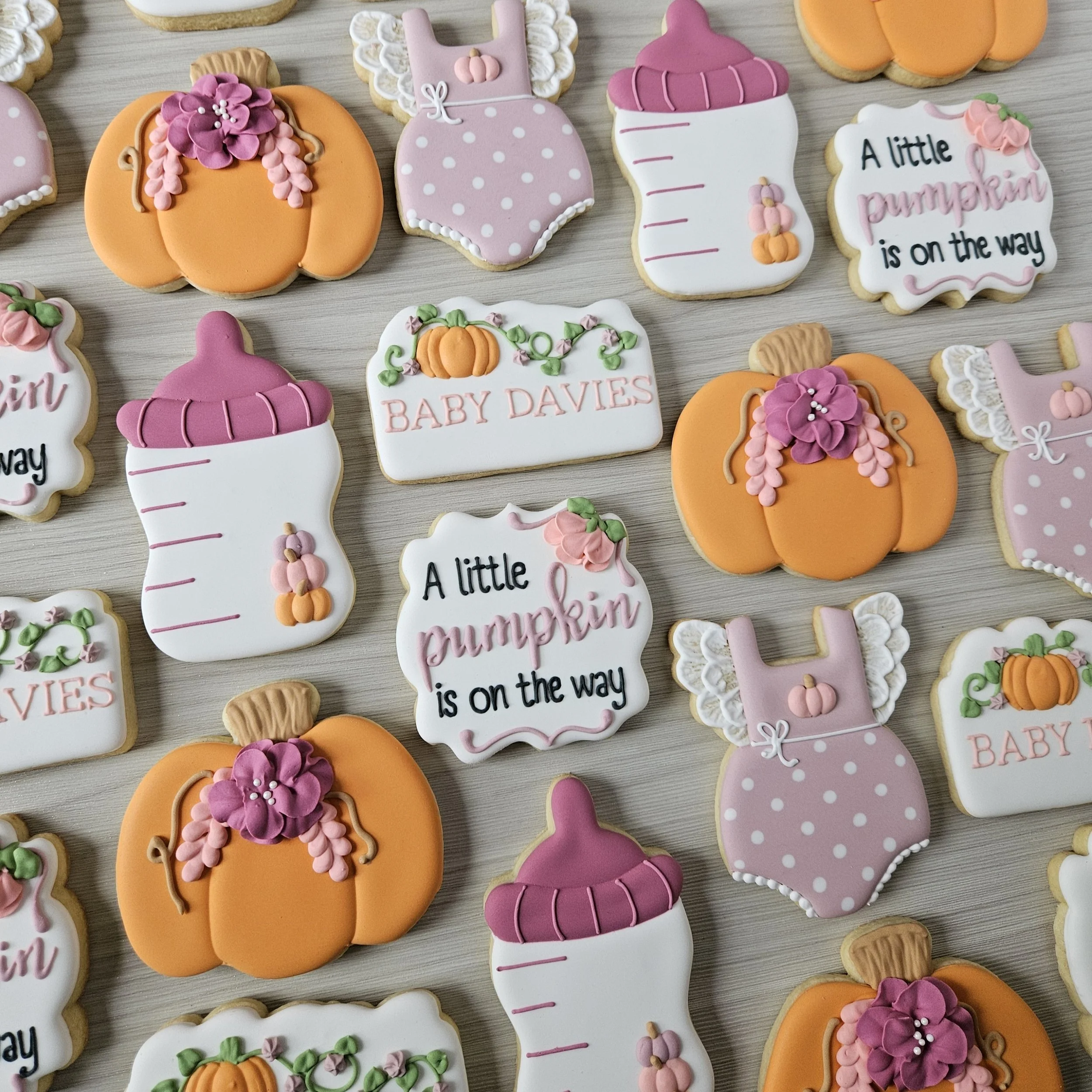 Decorated sugar cookies with pumpkin, baby bottle, and fall-themed messages for Thanksgiving or fall celebrations.