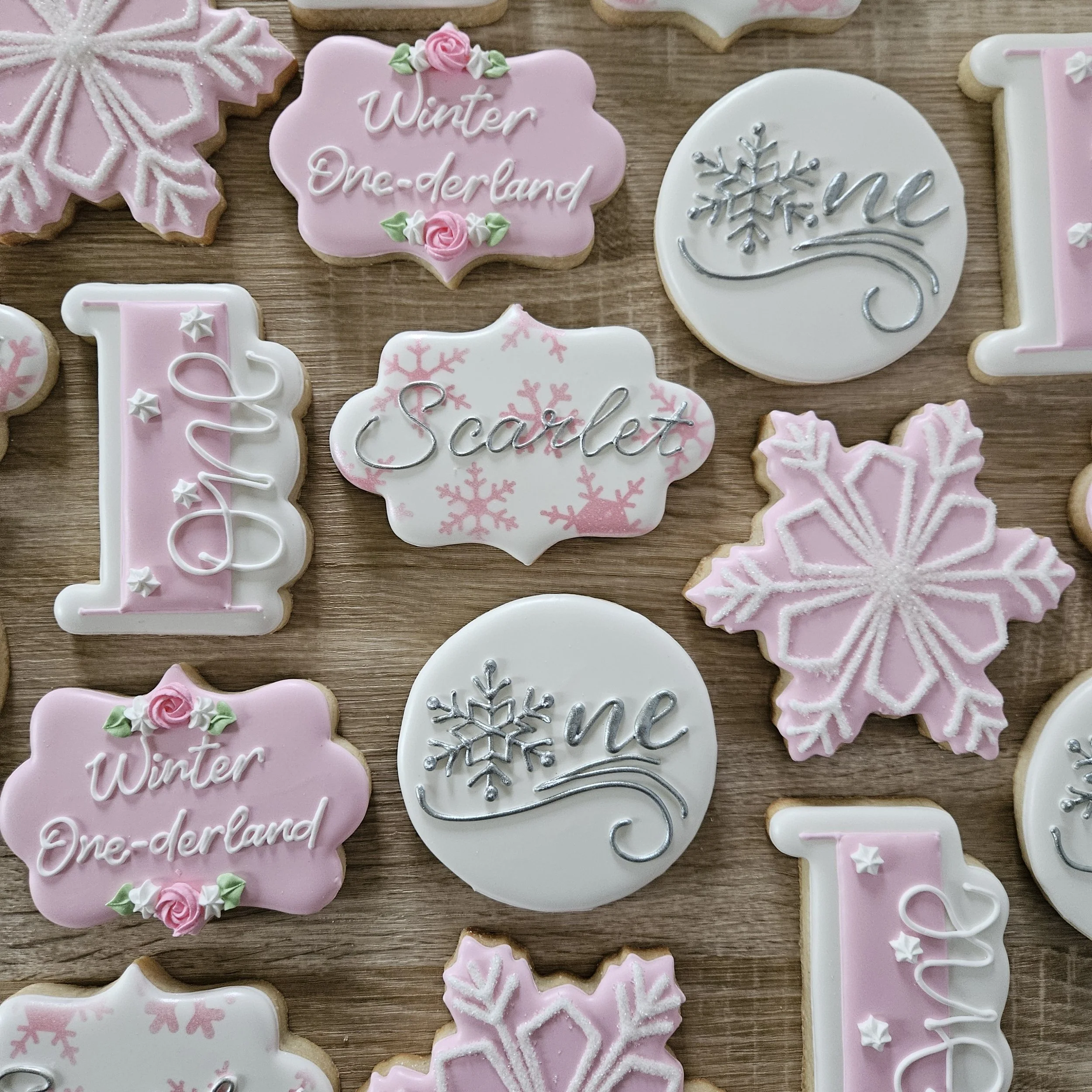 Decorated cookies with a winter wonderland holiday themes, including snowflakes and words like 'Winter' and 'Scarlet'.
