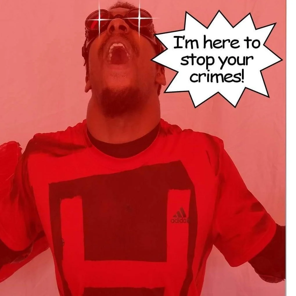 A man wearing sunglasses and a red Adidas sports shirt with a large black graphic. He is leaning back with his mouth open and eyes reflecting light. There is a speech bubble that says, 'I'm here to stop your crimes!'
