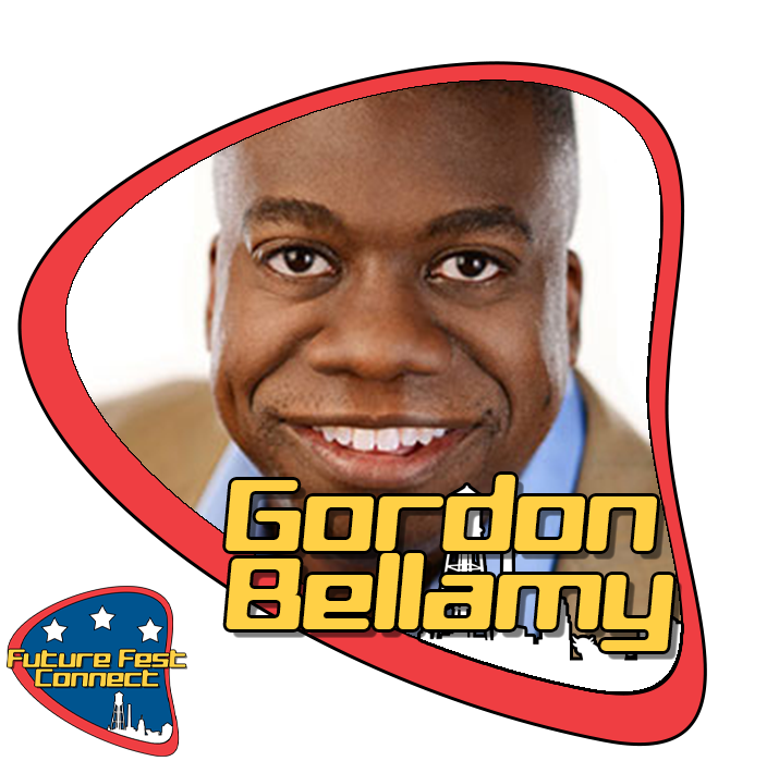 A smiling man with short black hair and dark skin, wearing a beige jacket and light blue shirt, with a background that is white near the face. The image includes a bold yellow font with black outline that says "Gordon Bellamy" and a logo in the botto