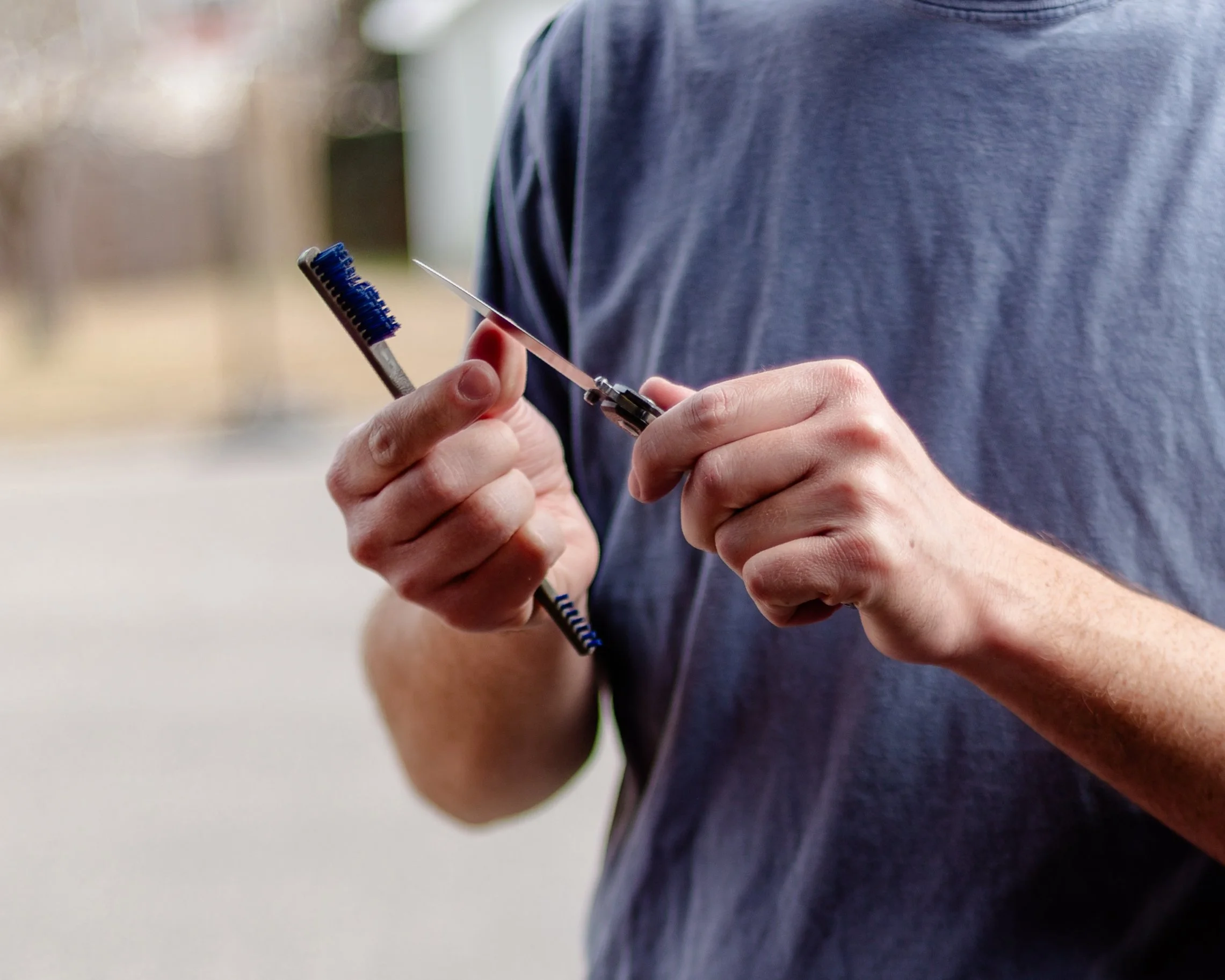Person holding a small knife and a brush.