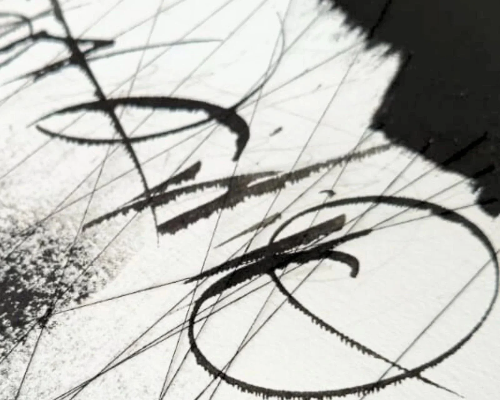 Tinta negra sobre papel que forma un patrón abstracto con líneas curvas y rectas.