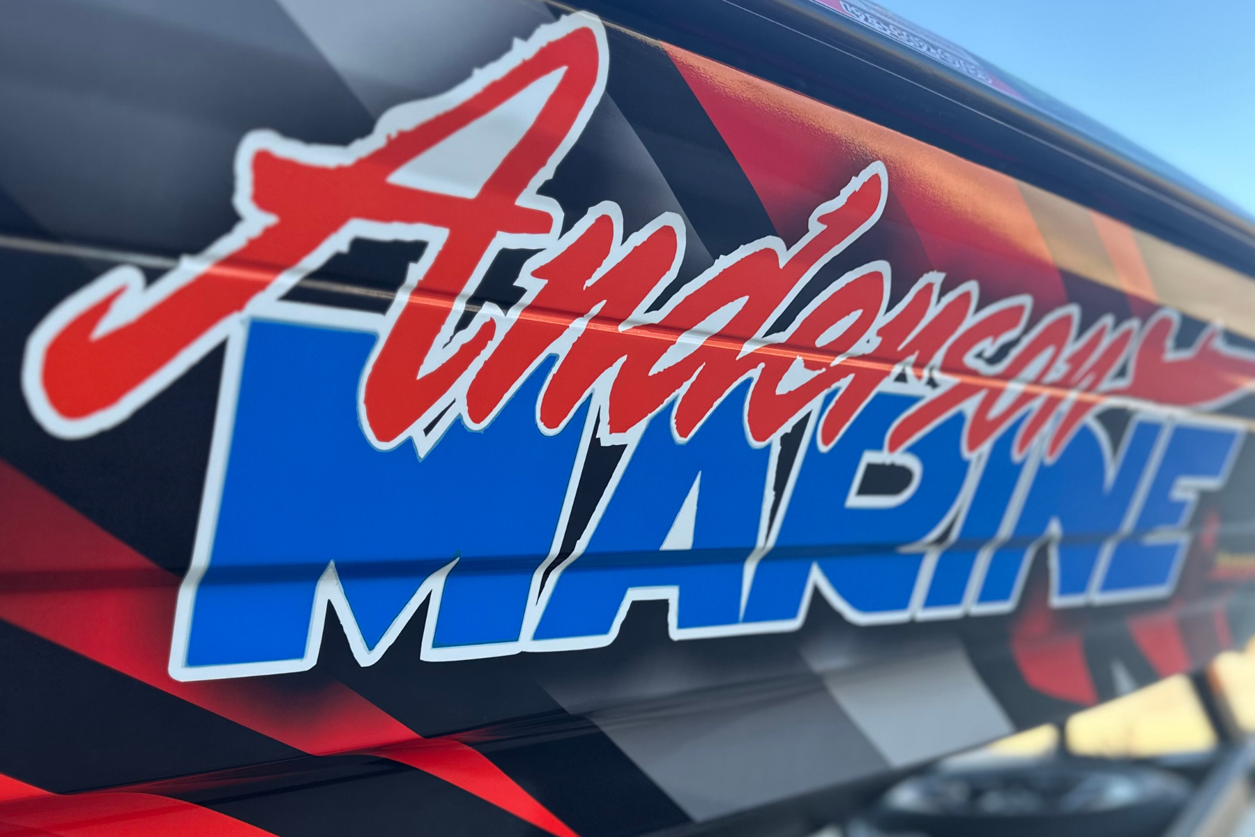 Close-up of a NASCAR stock car with a colorful decal that says 'Fascist Machine' in red and white stylized letters.