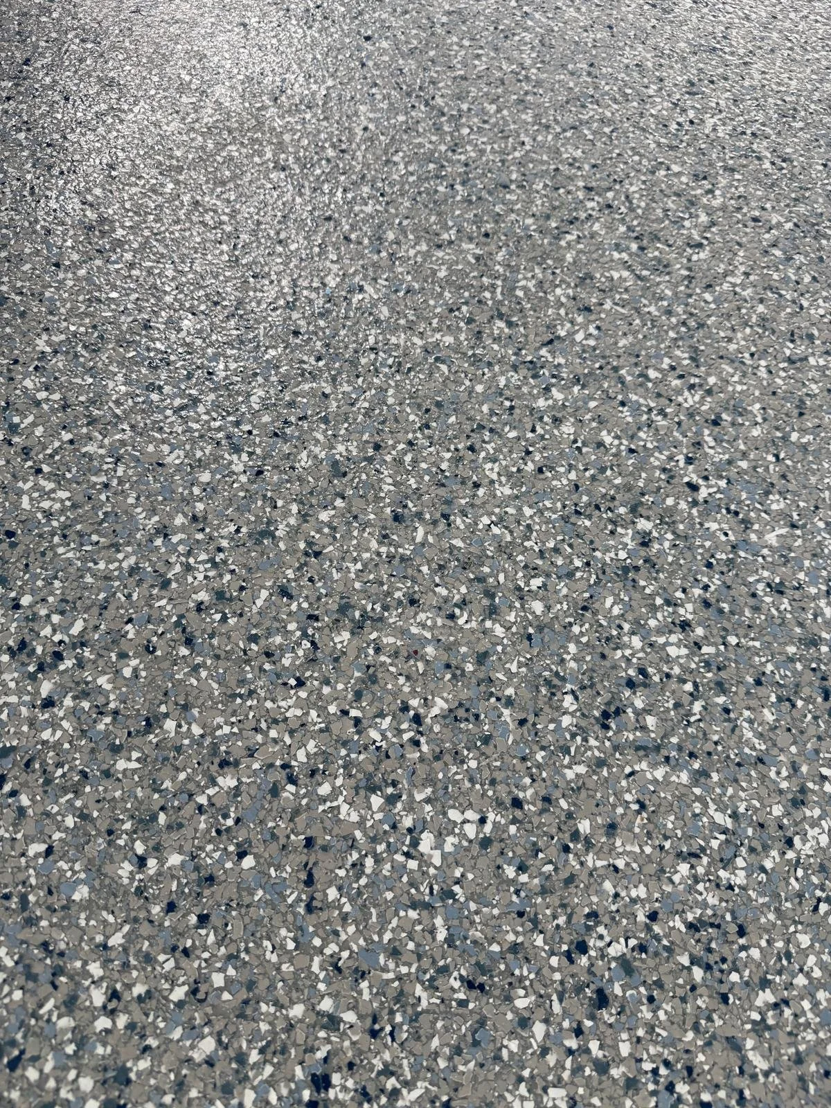 Close-up of a speckled gray and white terrazzo floor surface.