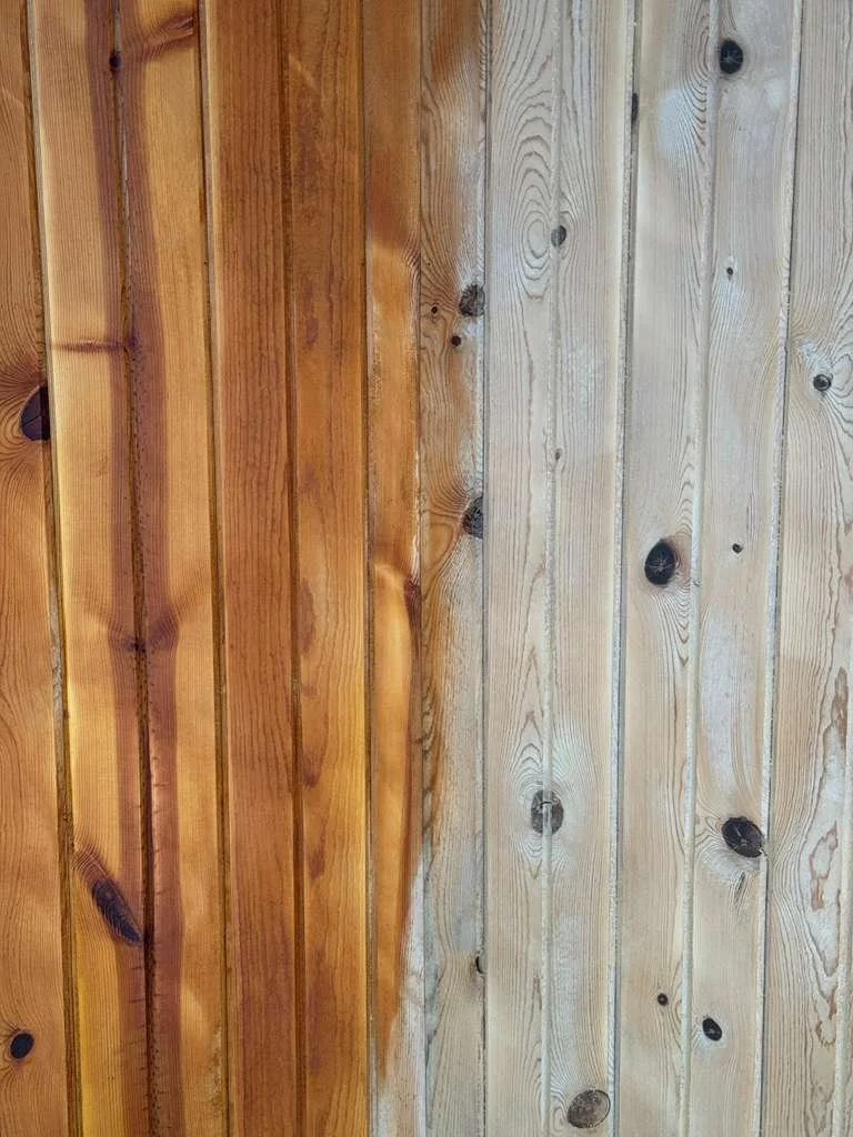 Split wood wall with one side stained a darker color and the other side left natural.