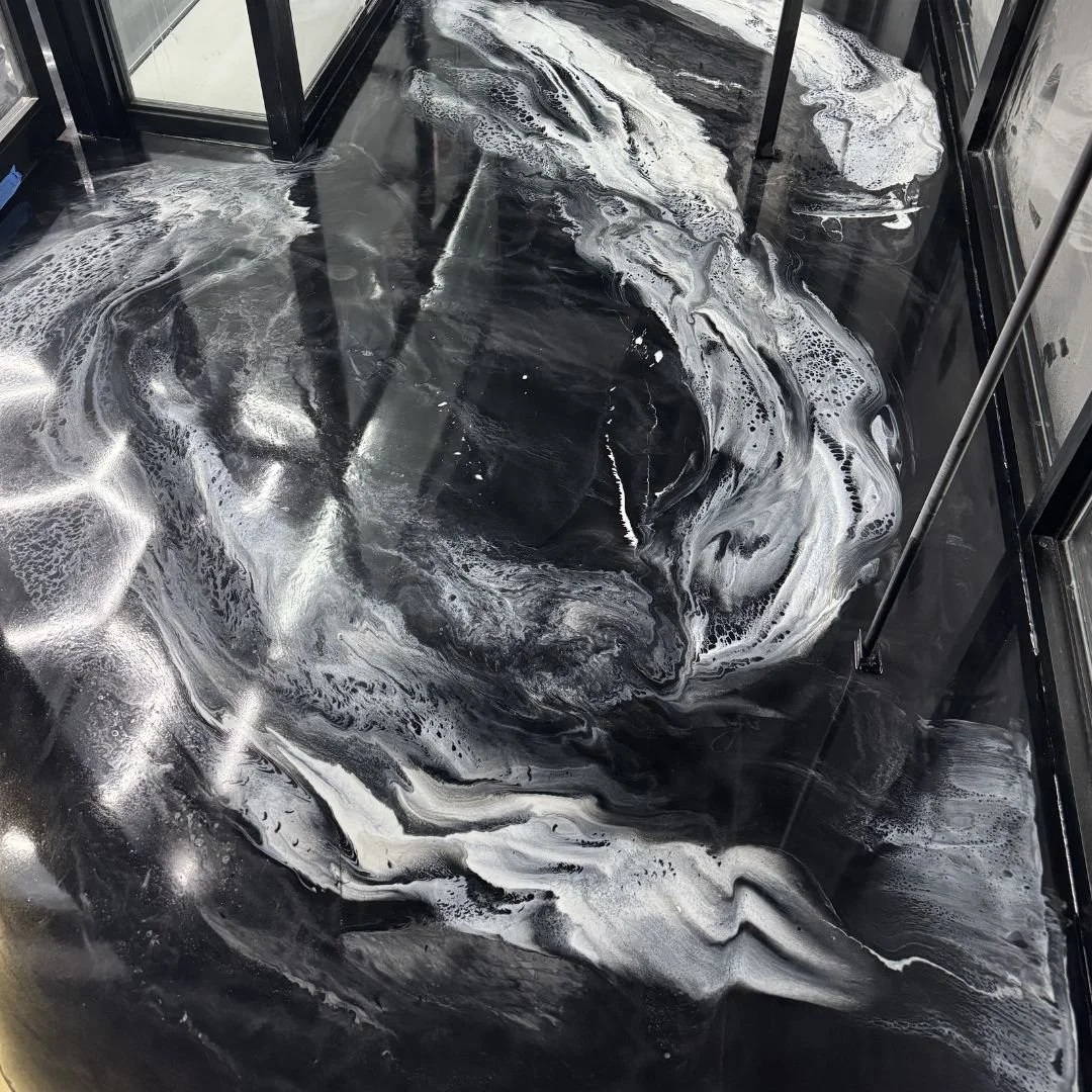 Black marble floor with white veins and intricate swirling patterns, reflecting light.