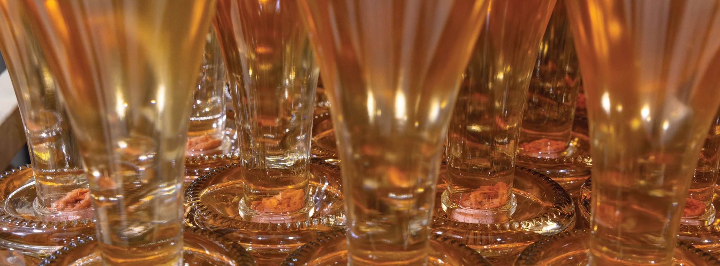 Close-up of sparkling wine bottles with a golden hue stored vertically with the yeast lees sediment sitting in the neck of the bottle ready for disgorging 