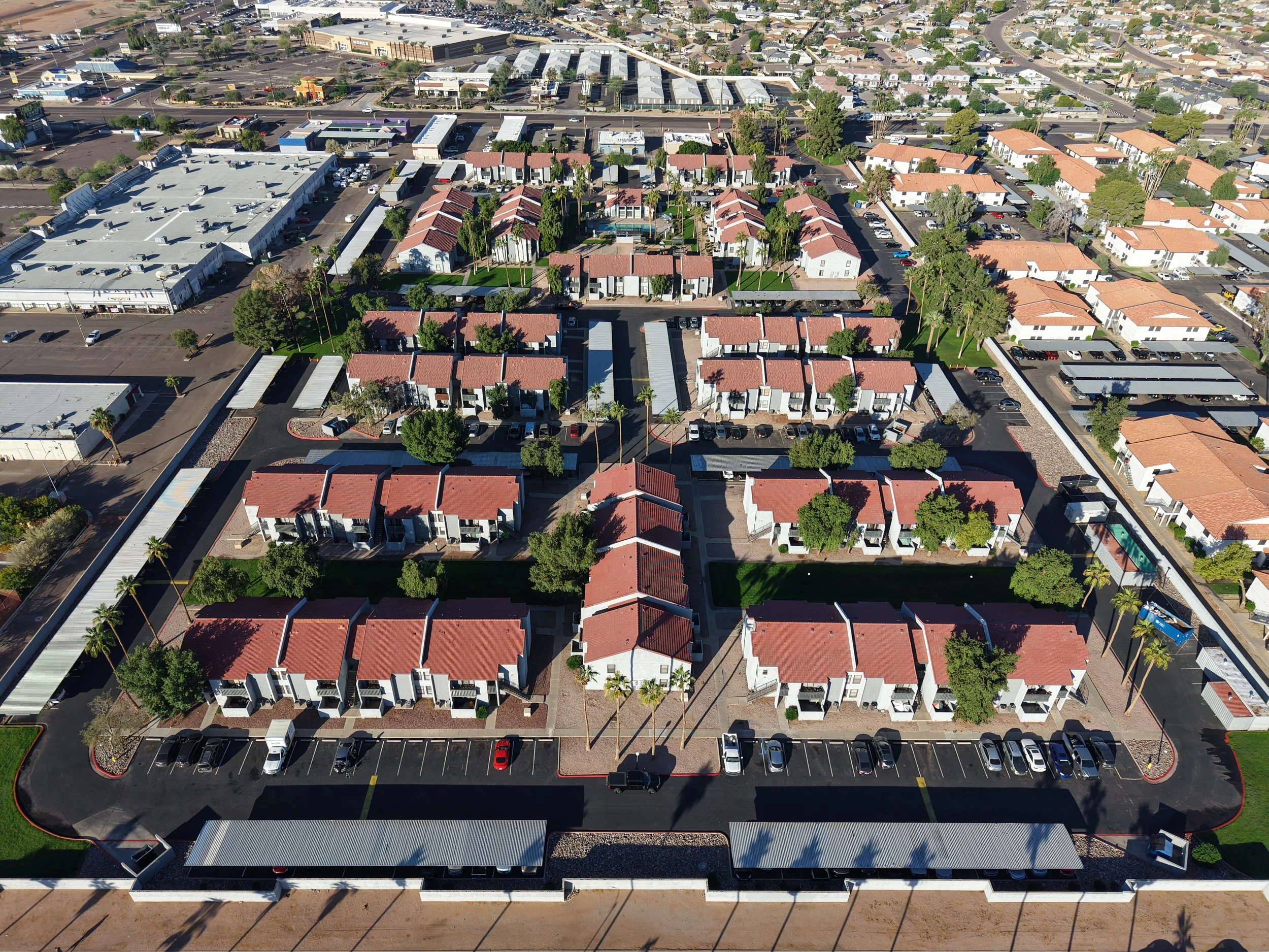 Aerial view of a residential apartment complex with multiple buildings, parking lots, and surrounding streets.