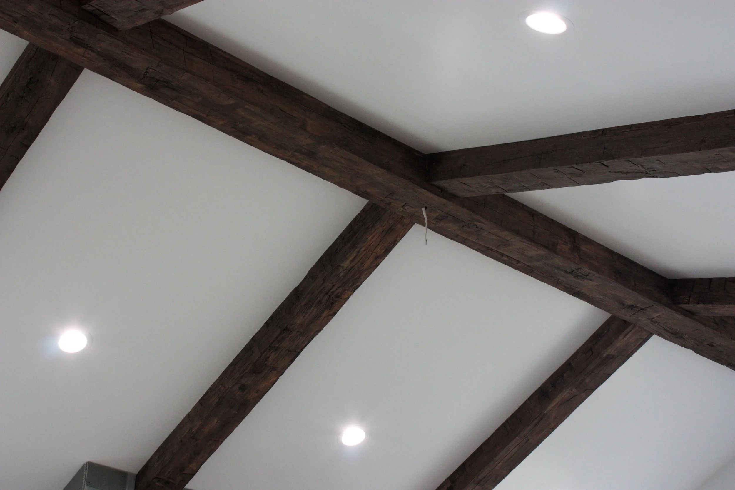 Ceiling with wooden beams and recessed lighting.